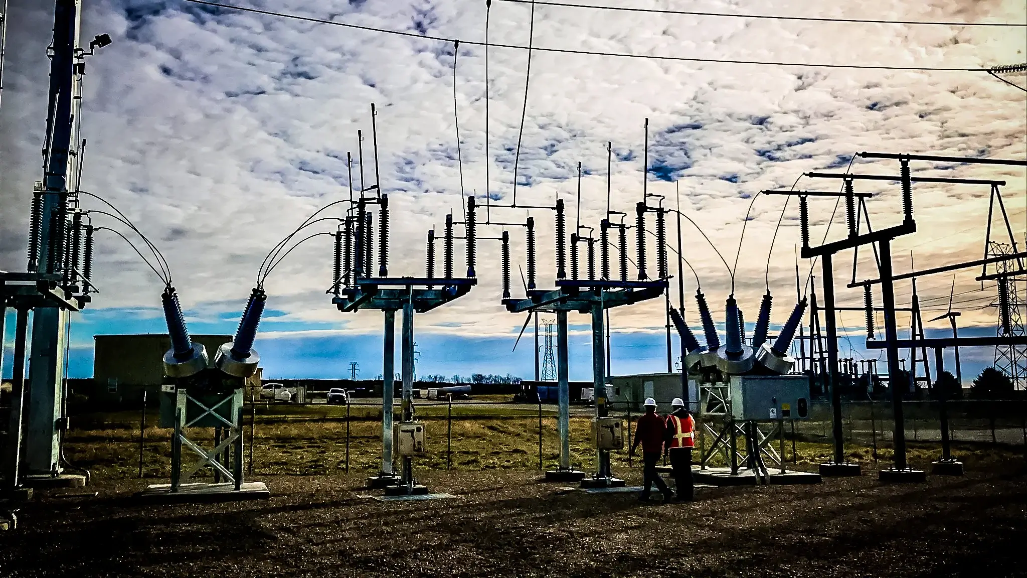 A lineworker in a Michels bucket truck uses a hot stick to work on a conductor line