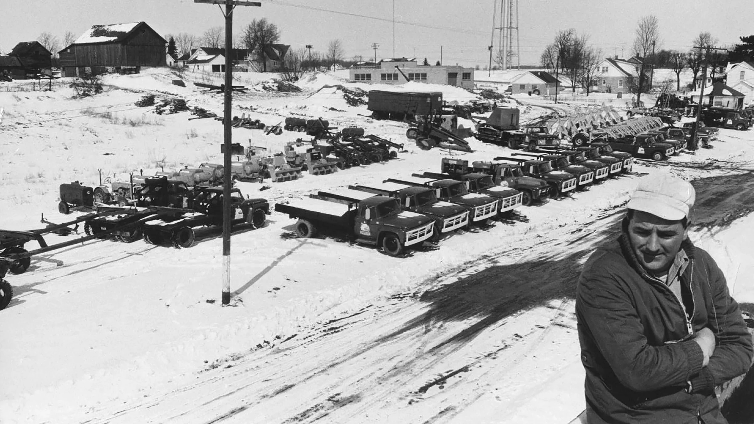 Dale Michels stands with Michels trucks in the background in an archival photo