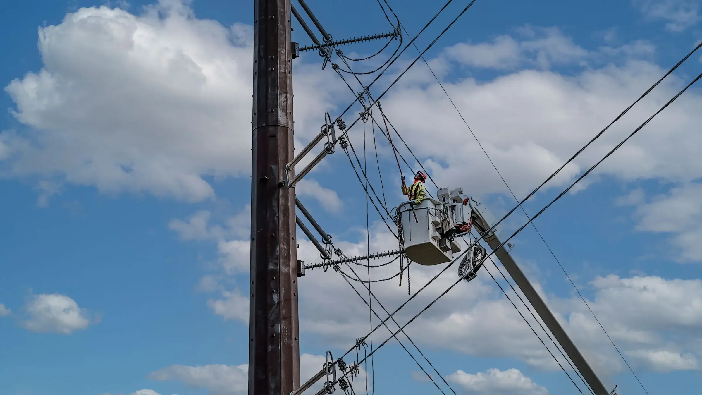 A Michels Power crew member operates on a power line from a bucket