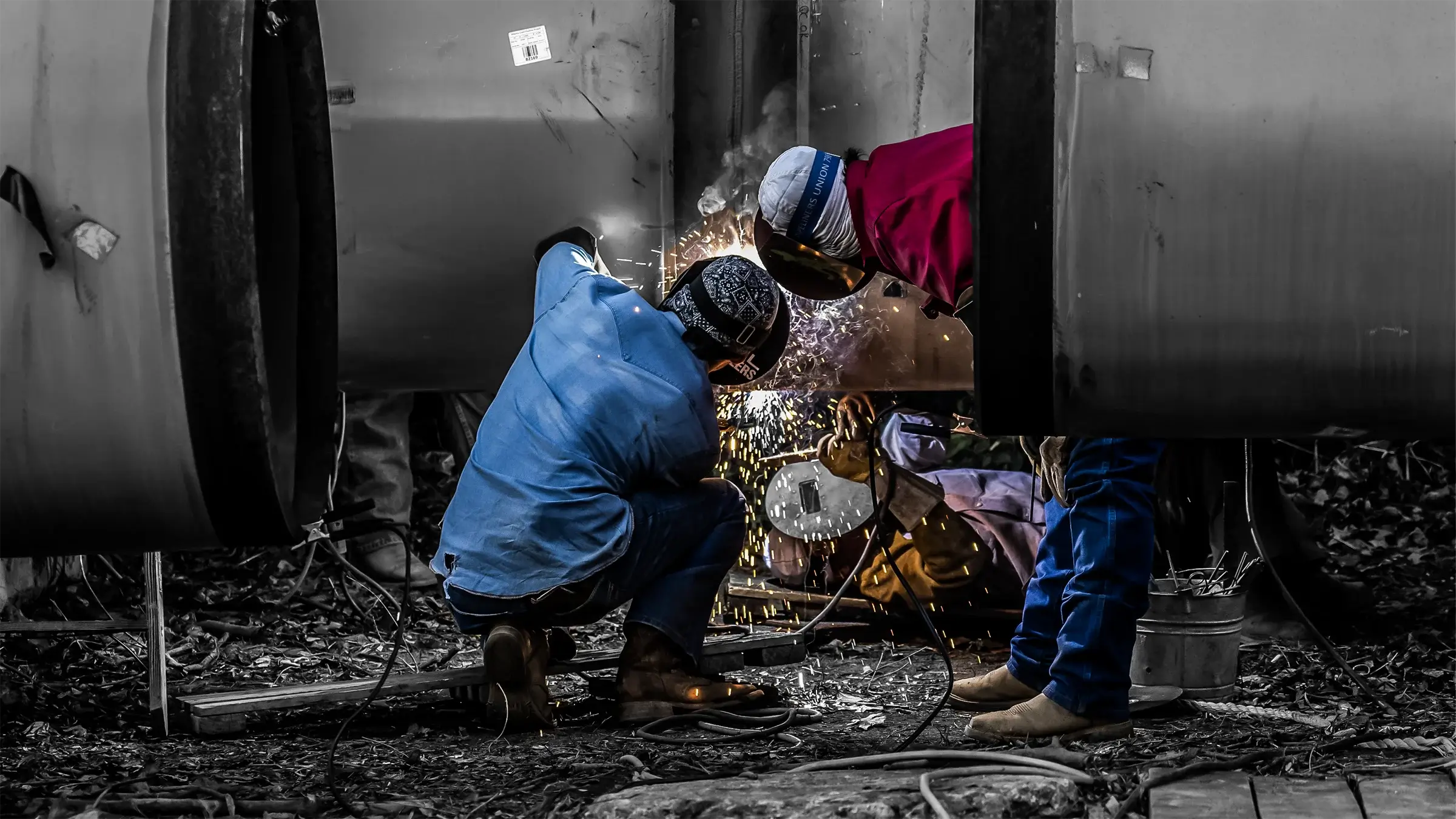 Three welders fuse large-diameter steel pipe