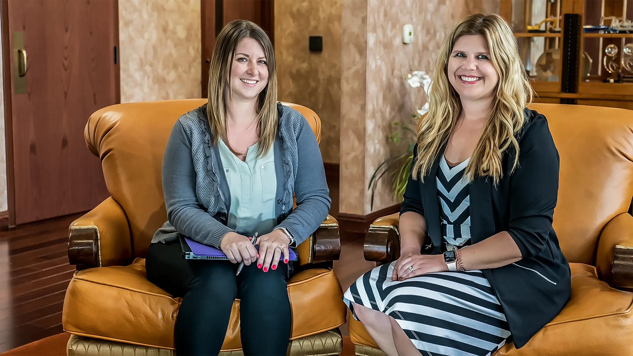 Two women sit in a lobby