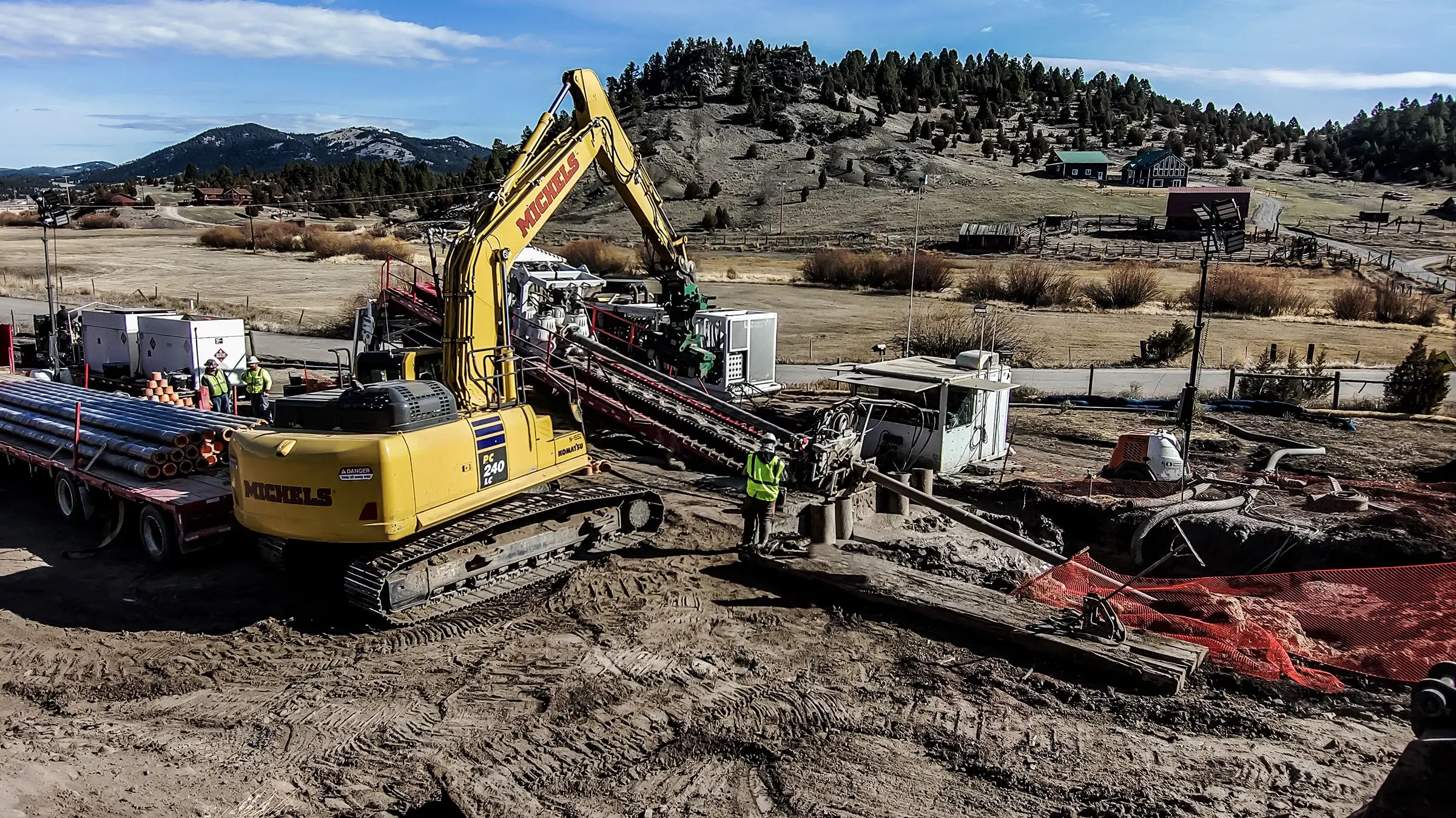 A drill rig is used in a mountainous area to drill a pilot hole for an HDD project