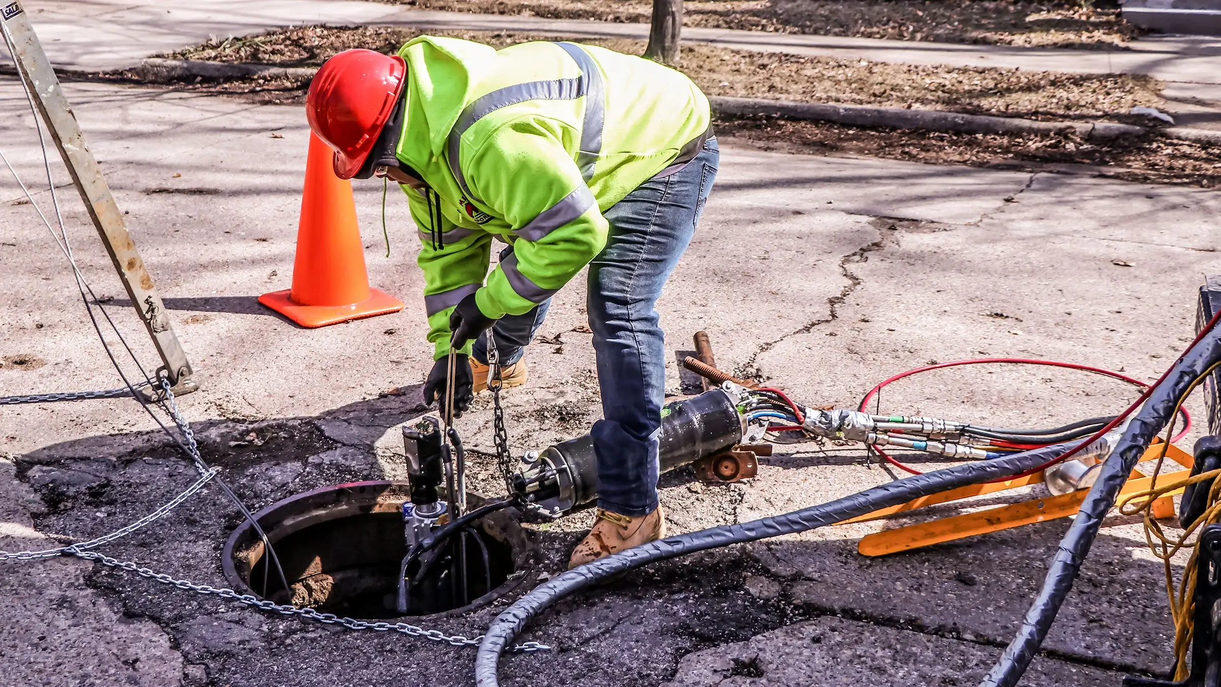 A grout packer is lowered into a manhole to fill a void and reduce inflow and infiltration of the sewer system