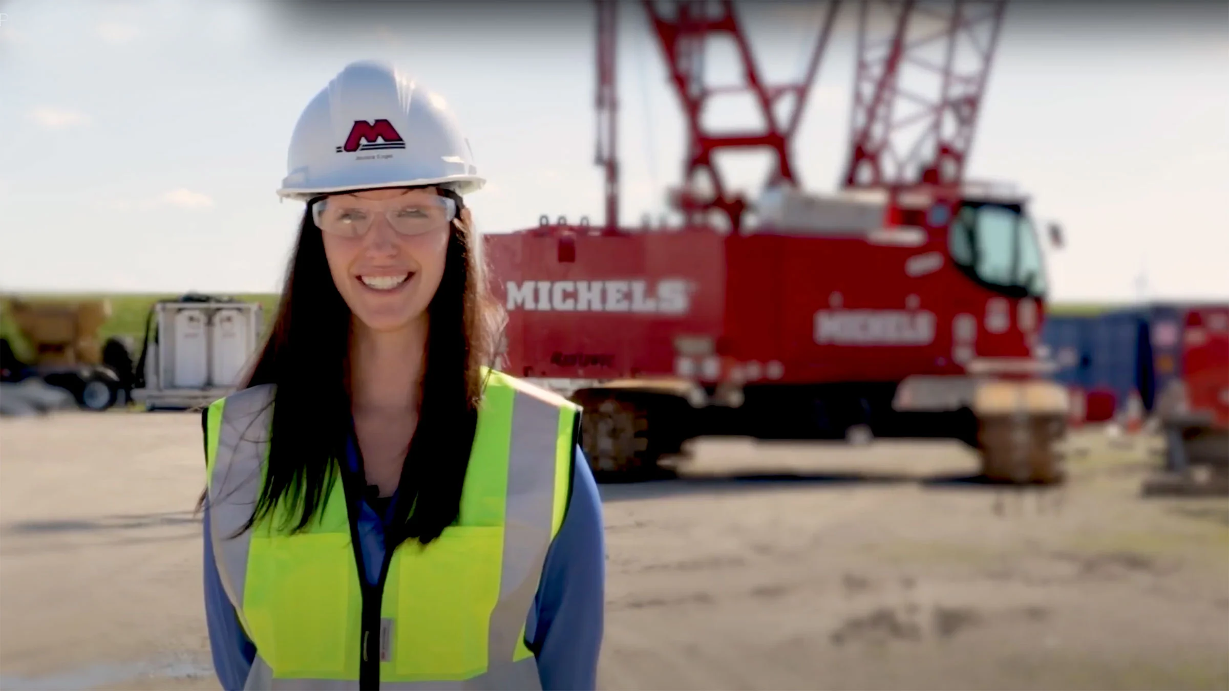 Female stand in fron of crane and other equipment with PPE on