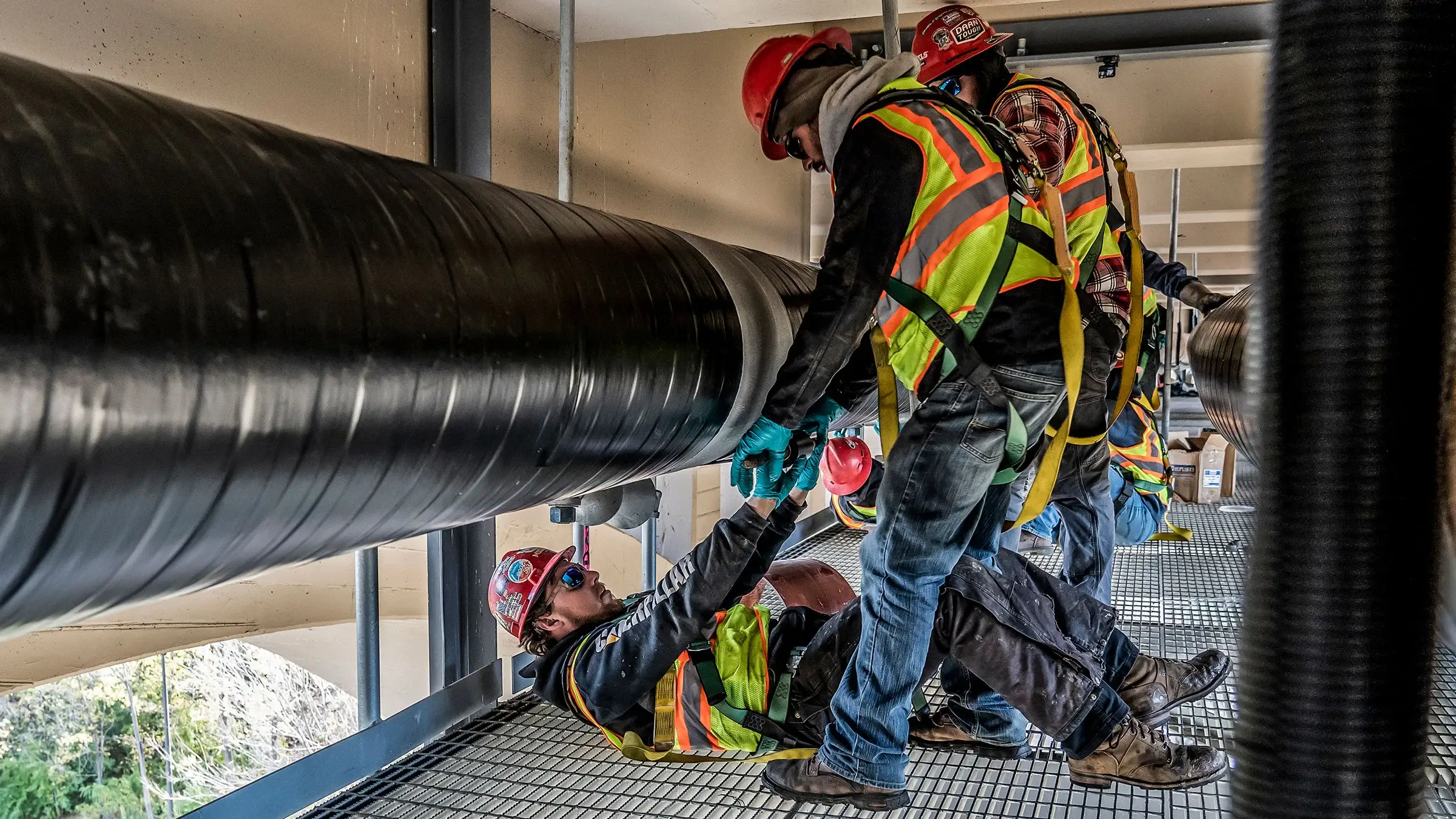 Michels Utility Services crew uses team work in fastening natural gas pipeline under bridge in Minneapolis Minnesota