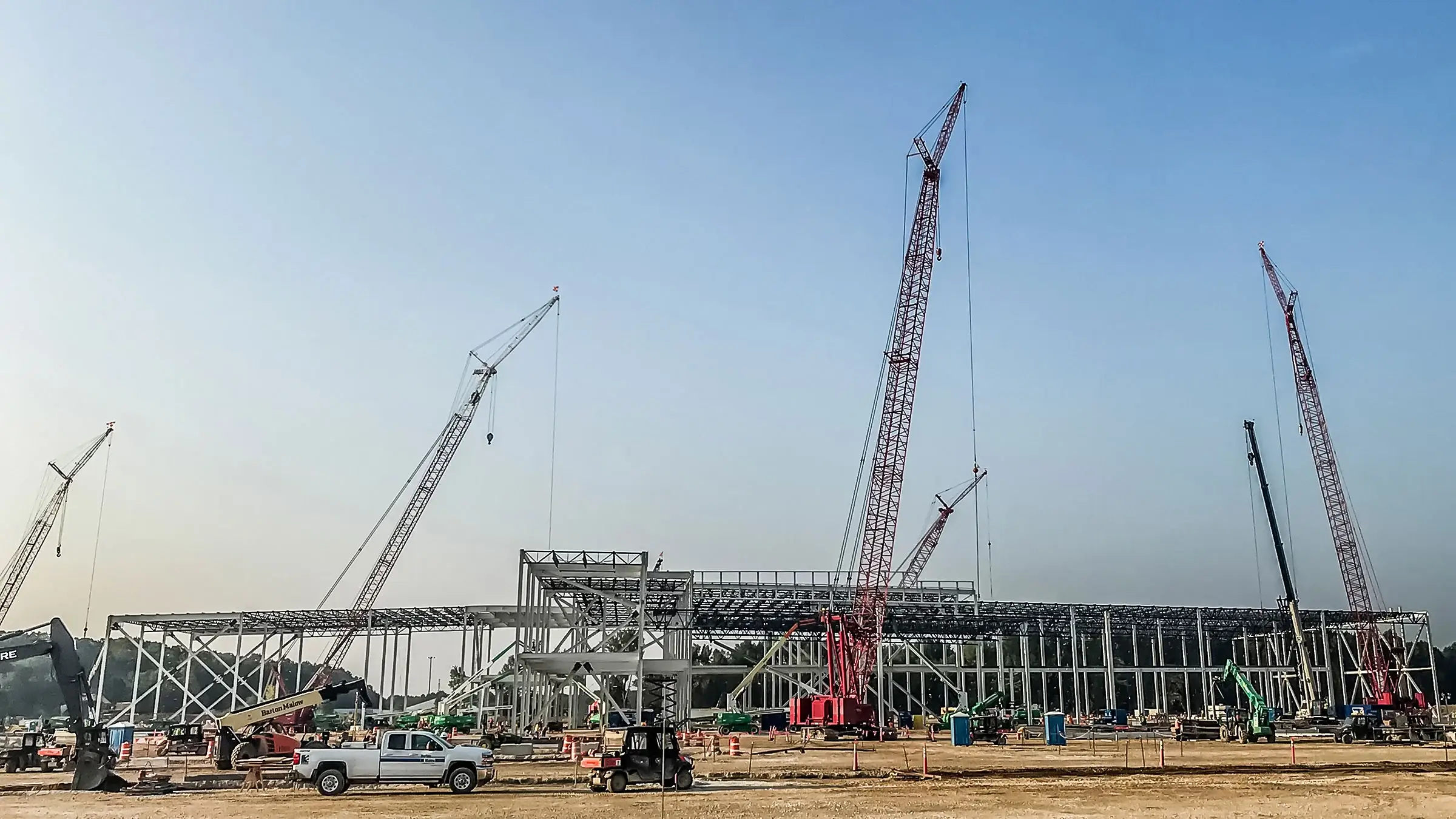 Cranes assemble framing for a battery manufacturing plant being built