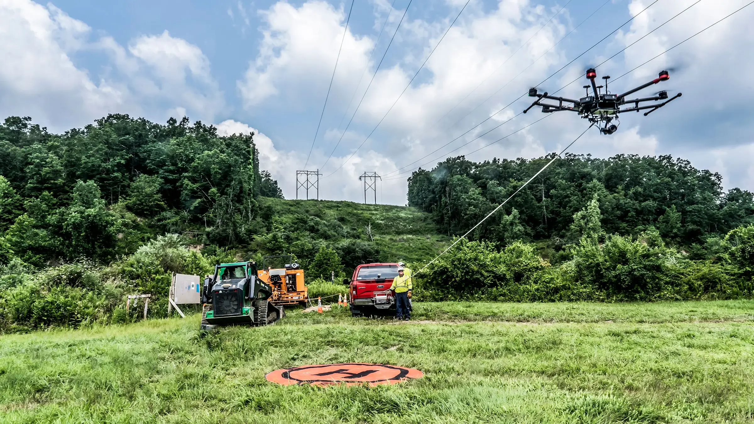 Power crew uses drone to measure area in a grassy field