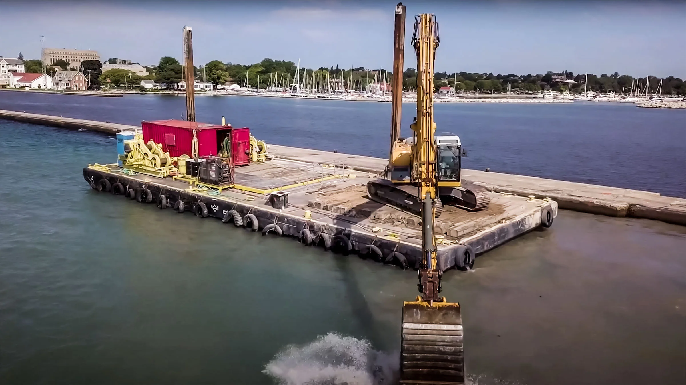 A large excavator machine digs into Lake Michigan