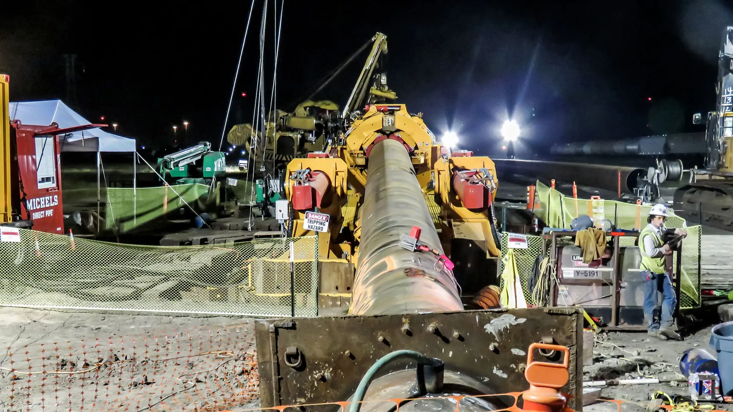 A Direct Pipe machine operates on a jobsite at night.