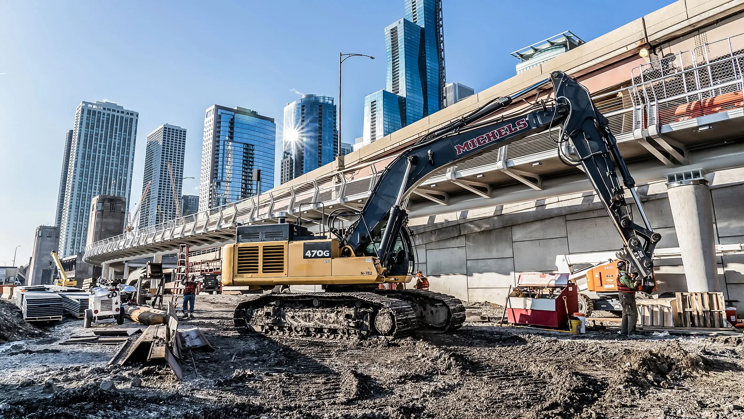 A Michels excavtor near a Chicago bridge and skyscrapers