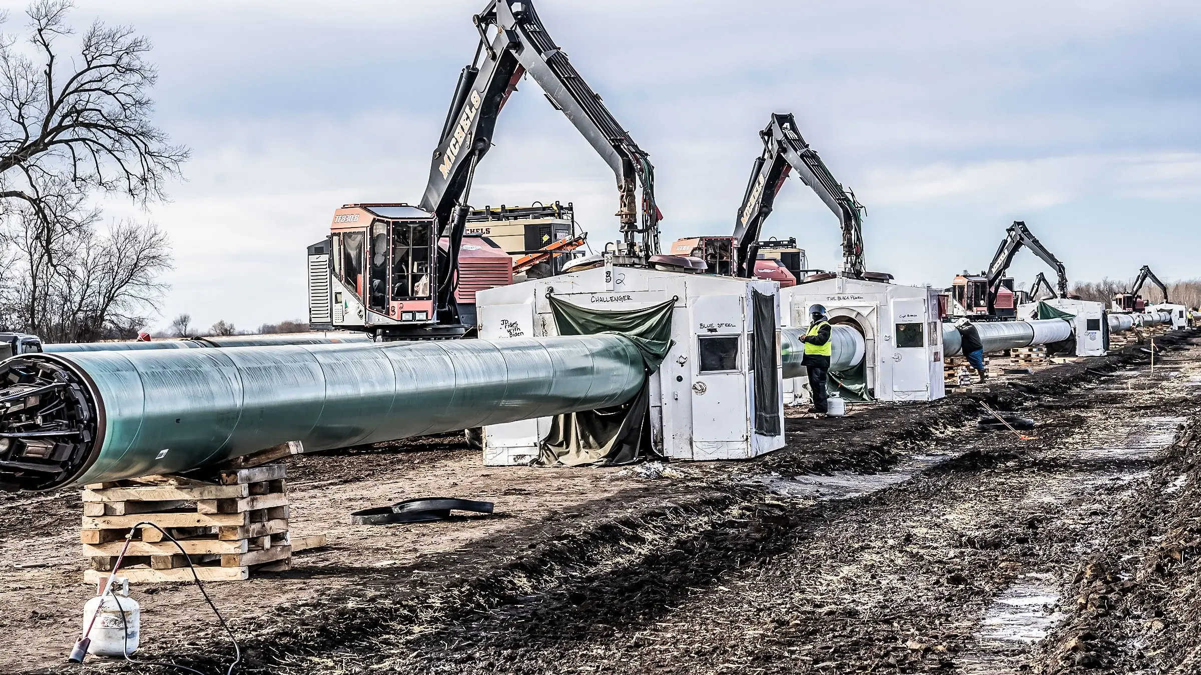Weld shacks are placed over pipeline to be welded before being placed in the ground