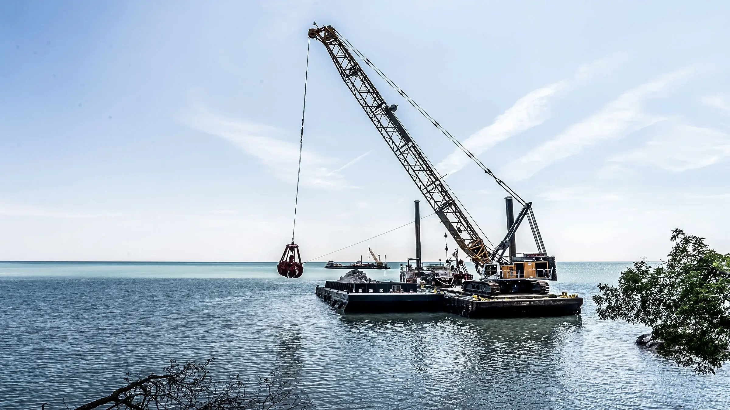 A crane works off-shore from a barge in Lake Michigan