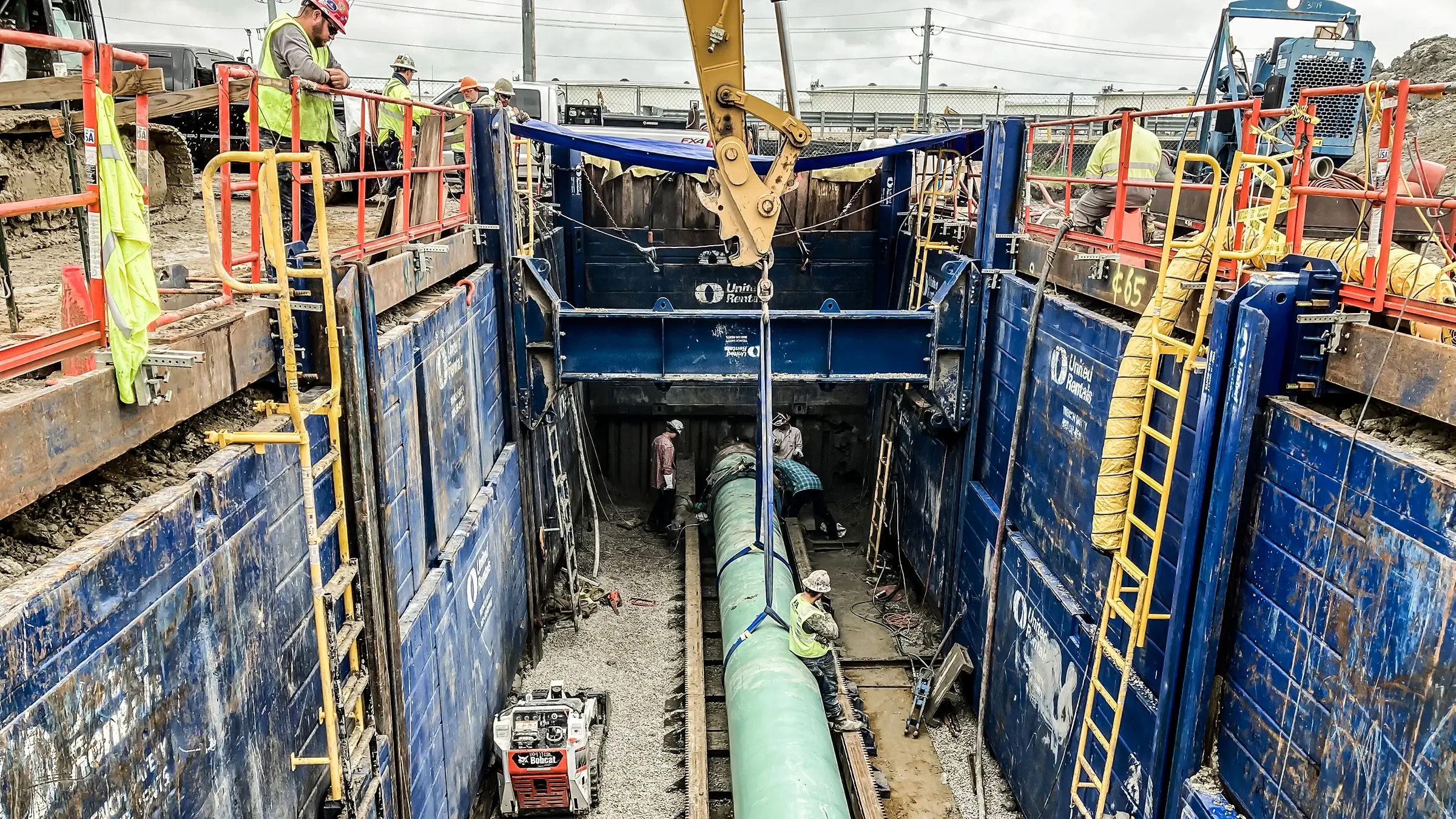 Excavator lowers pipeline into place that will transport crude oil
