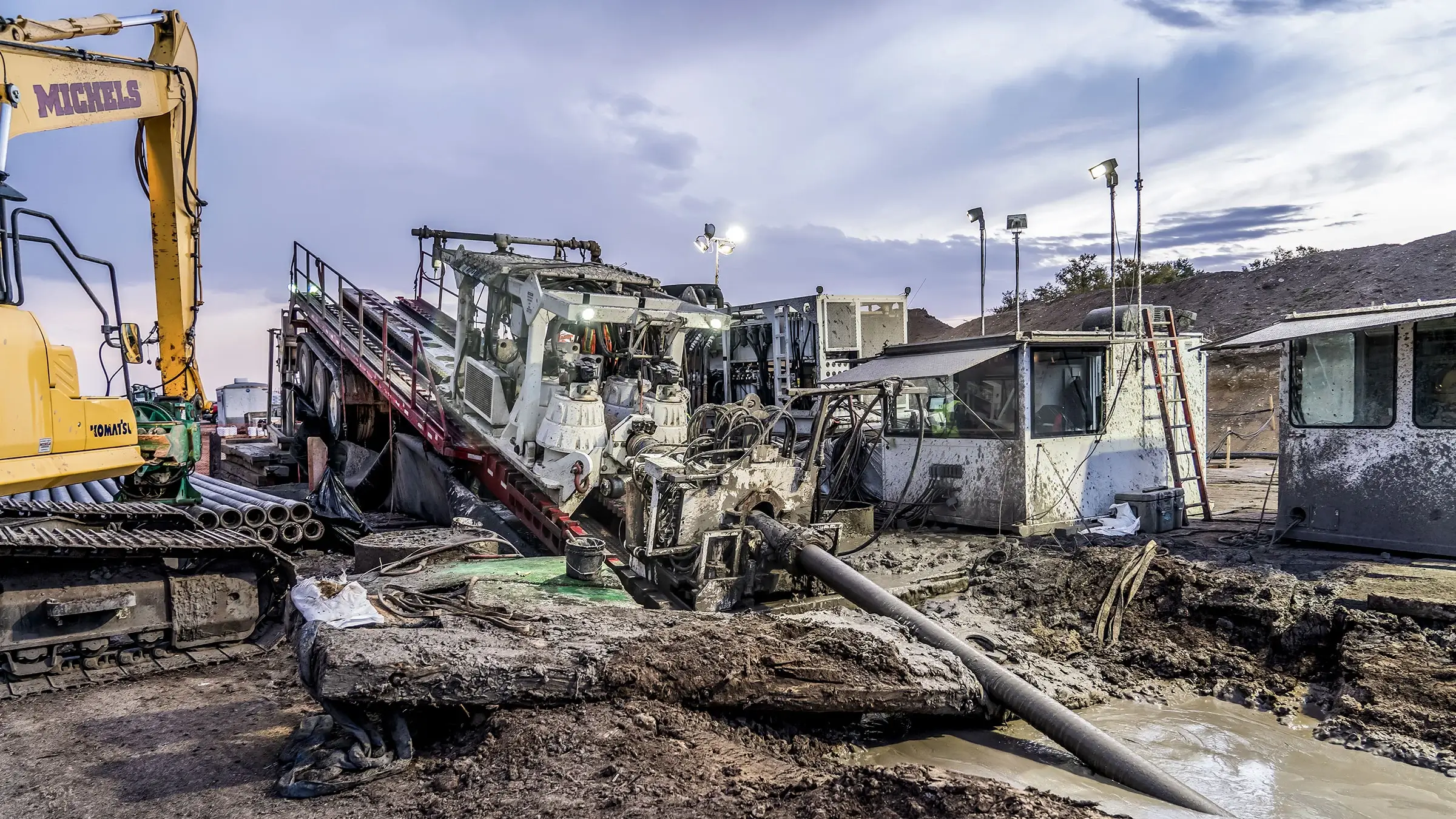 An HDD rig drills into a muddy pit of ground.