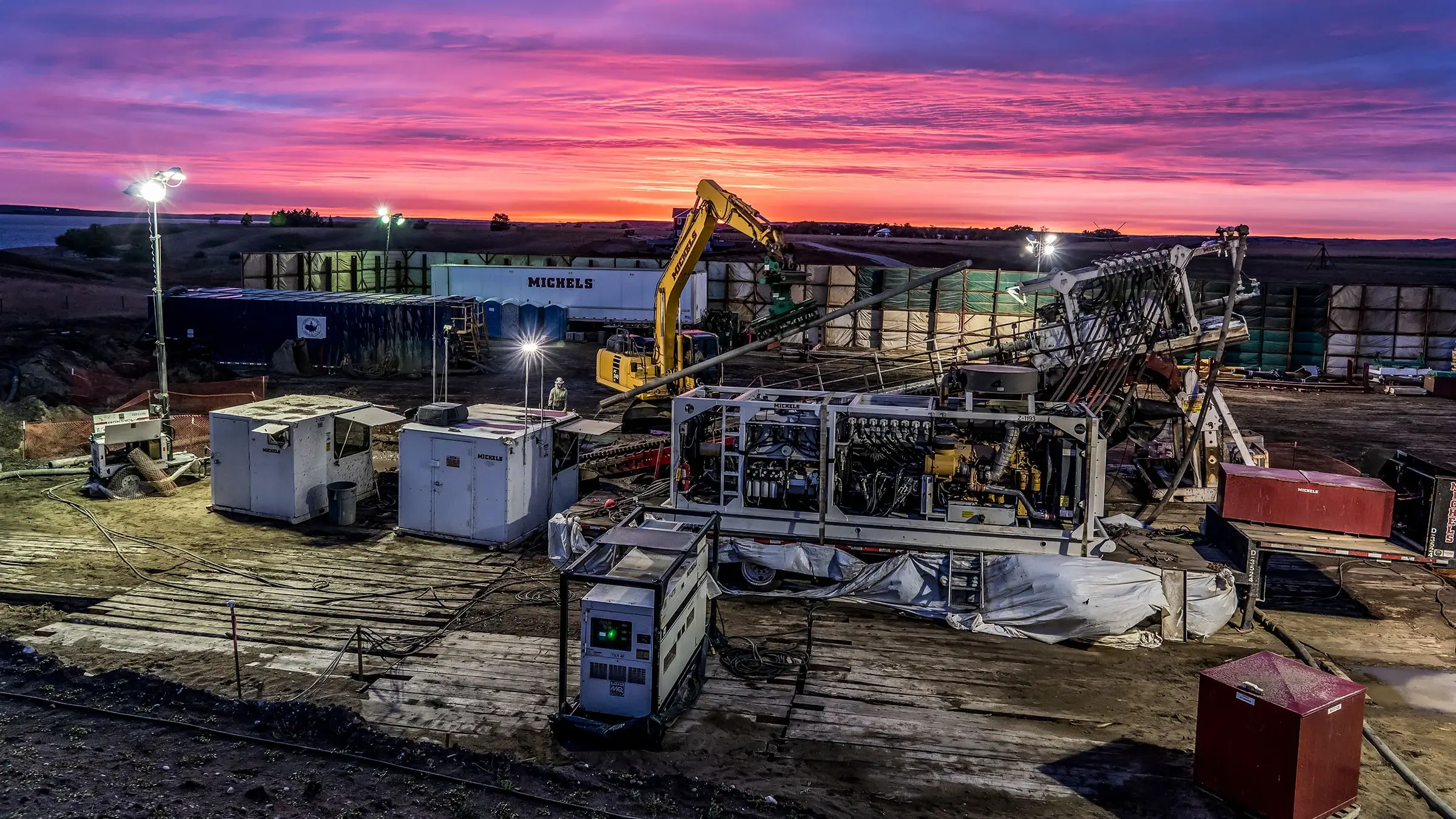 An HDD rig drills into the ground during a magnificent sunset.