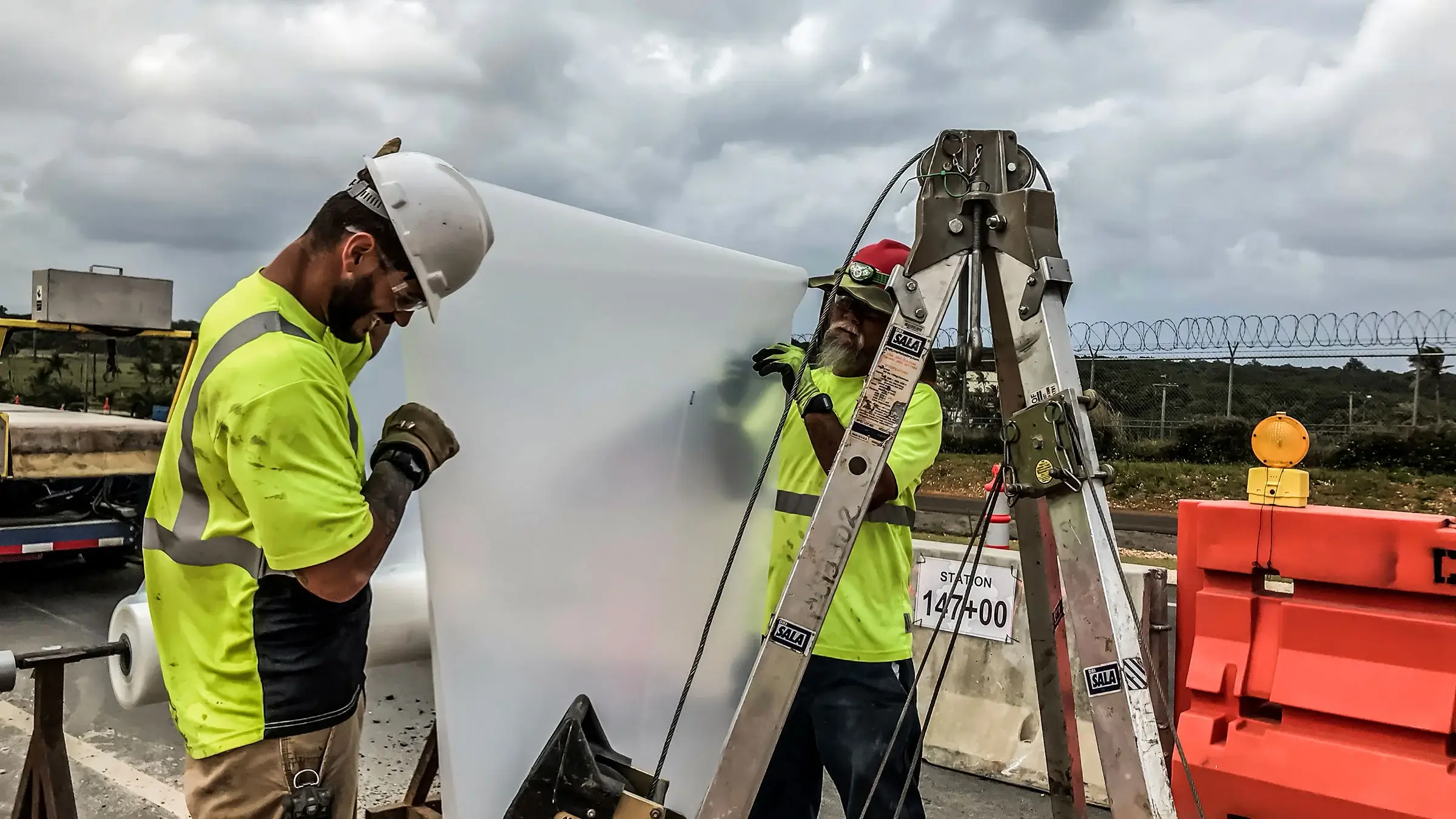 Two trenchless crew members measure out protective material for sewer rehab in Guam
