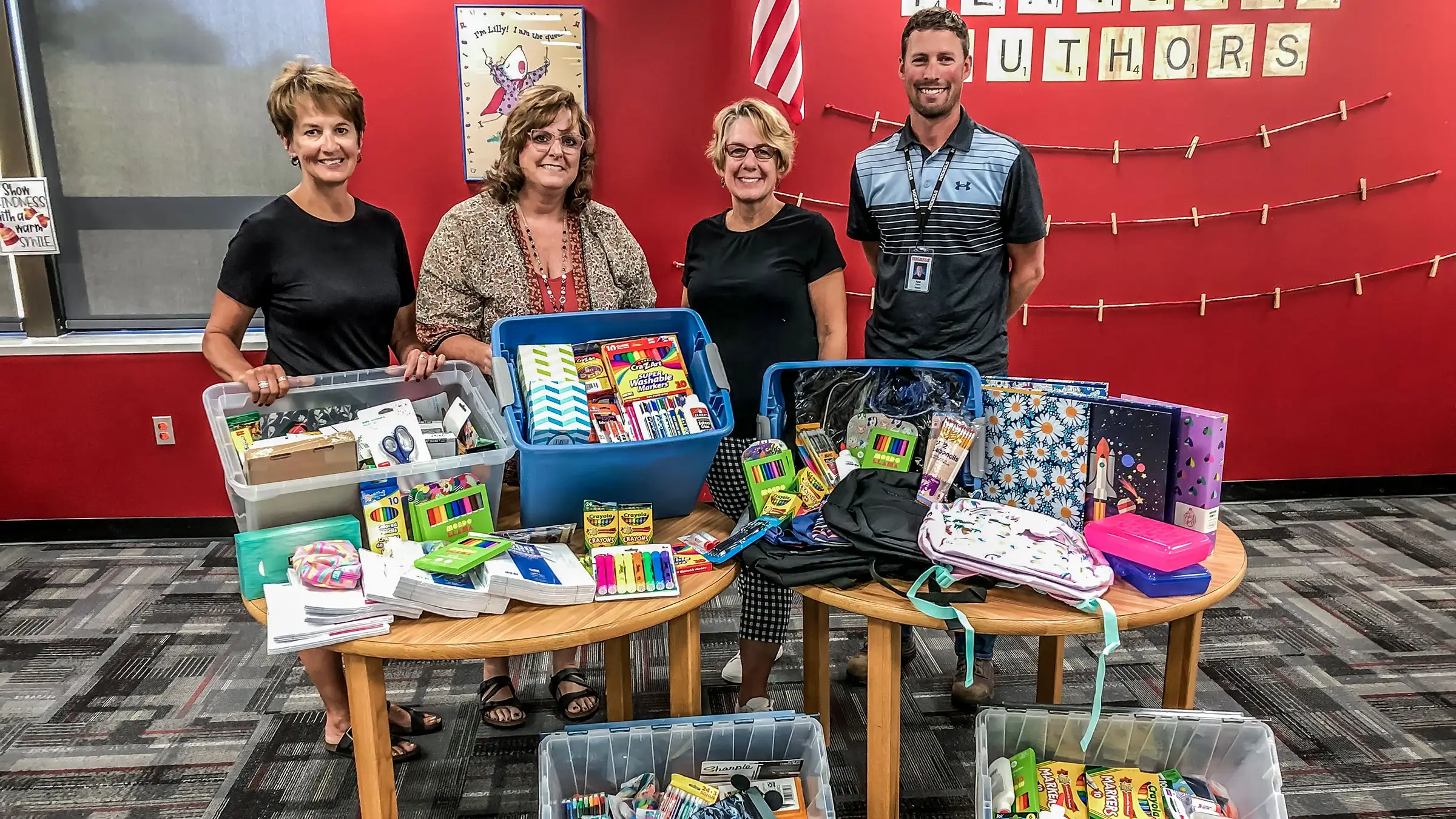 Employees show off items collected for the School Supply Drive.