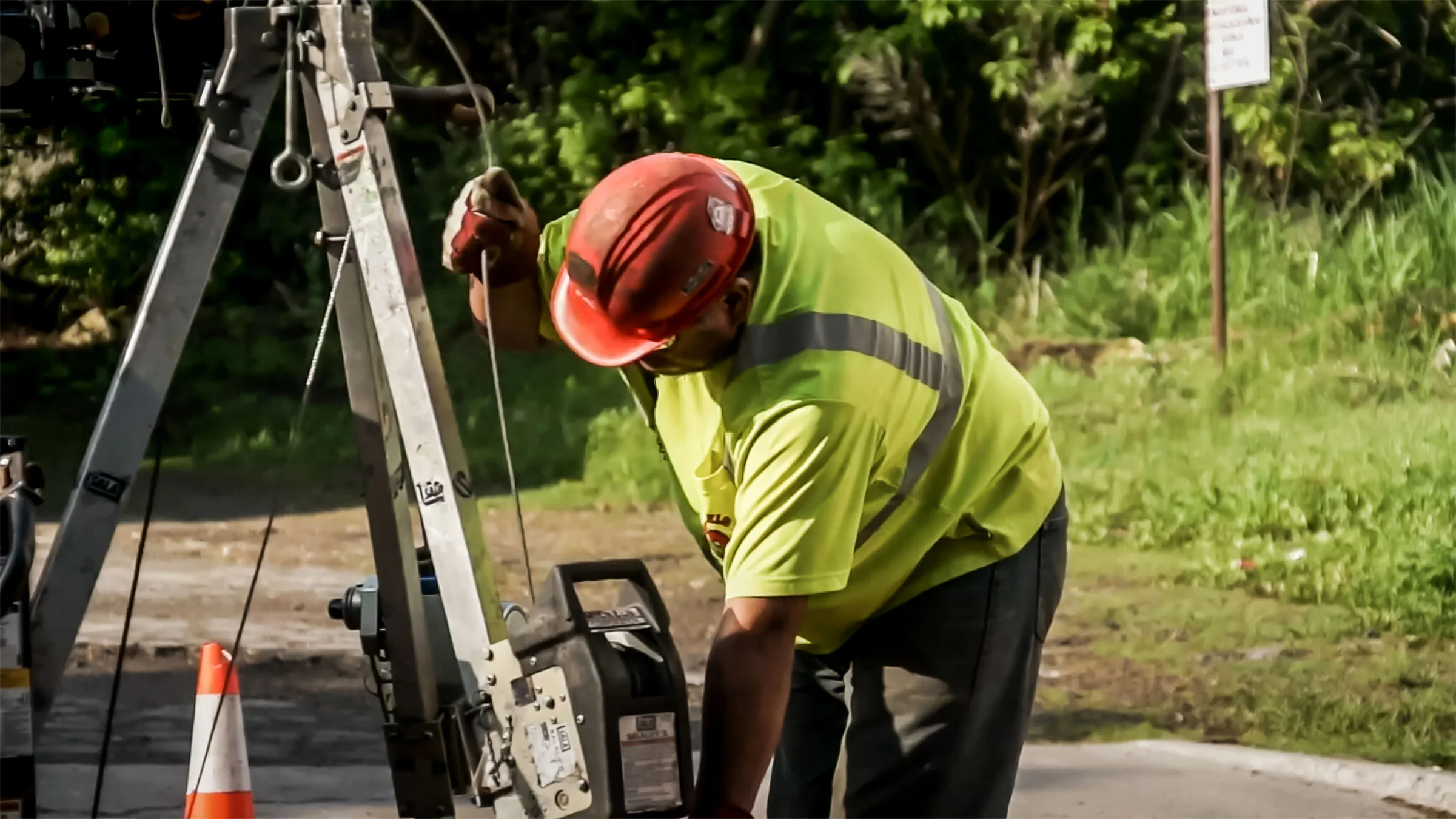 A Michels worker handles a metal wire on a piece of equipment.