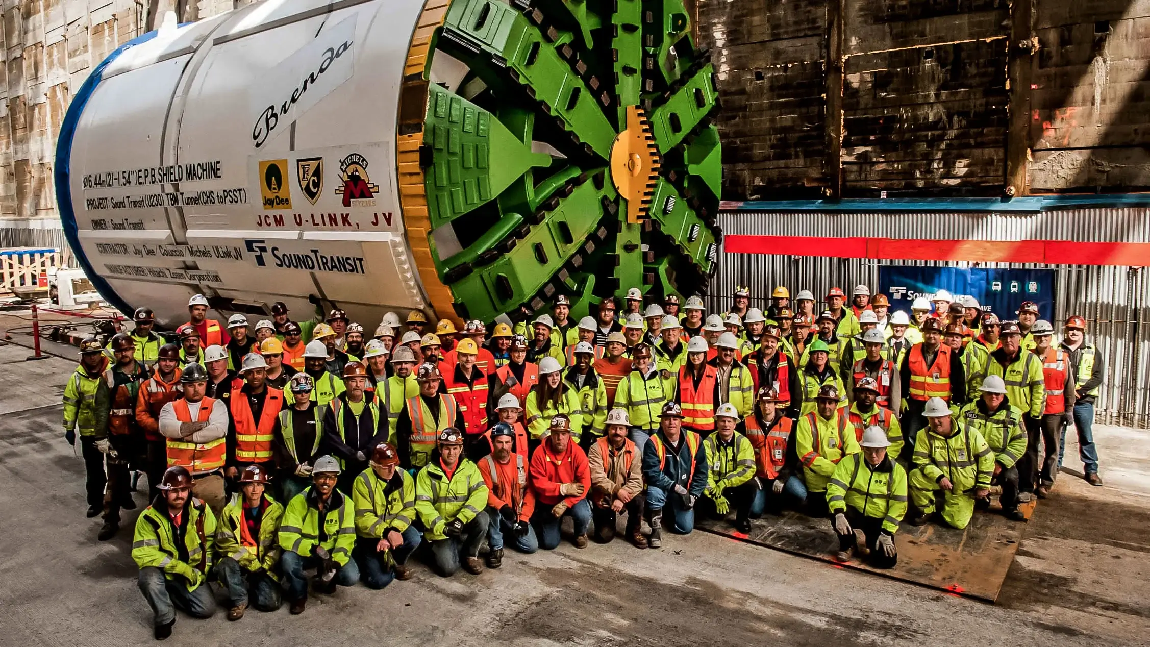 A Michels tunneling crew stands in front of a large tunneling drill.