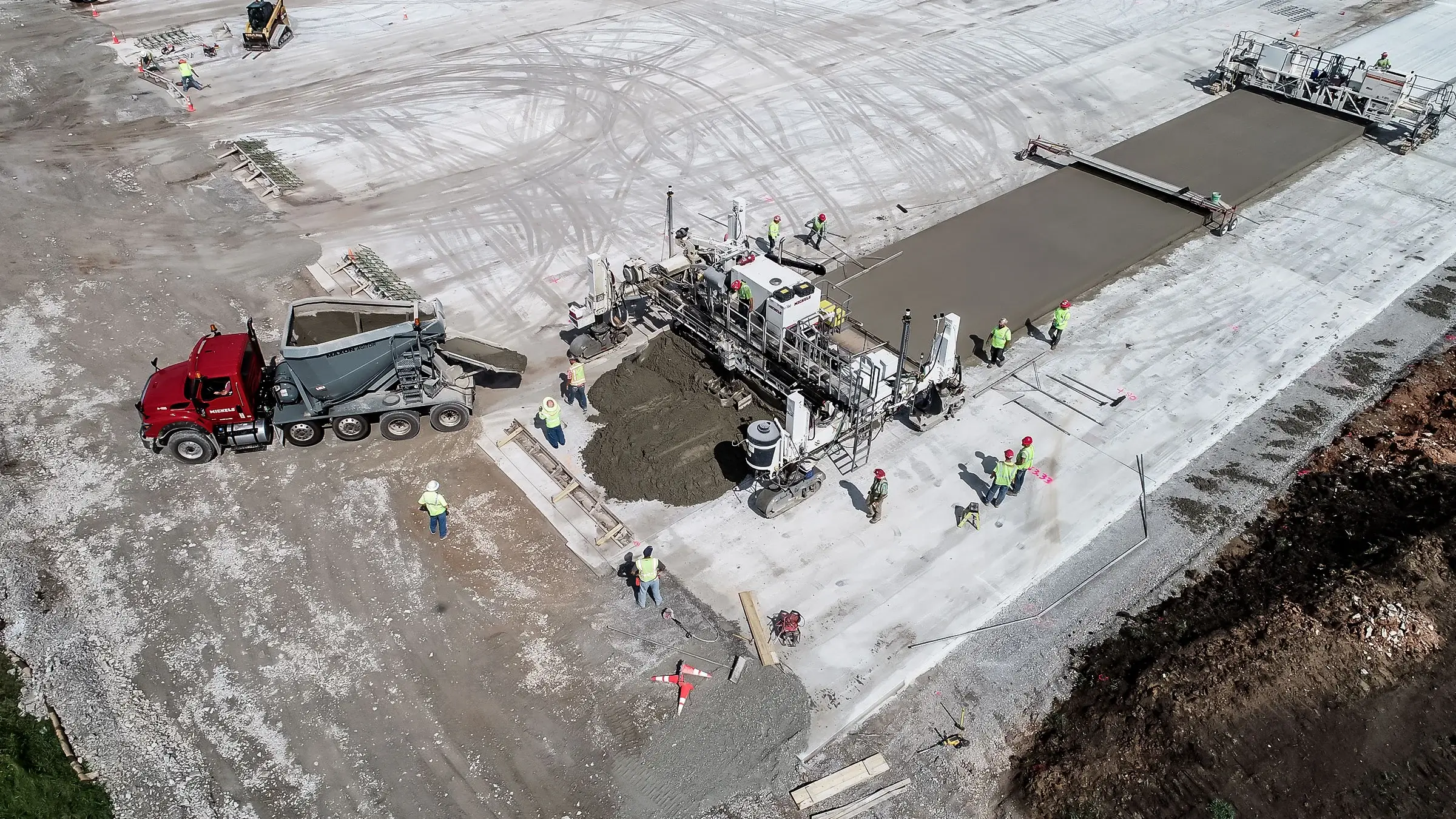 Paving machines lay concrete at an airport