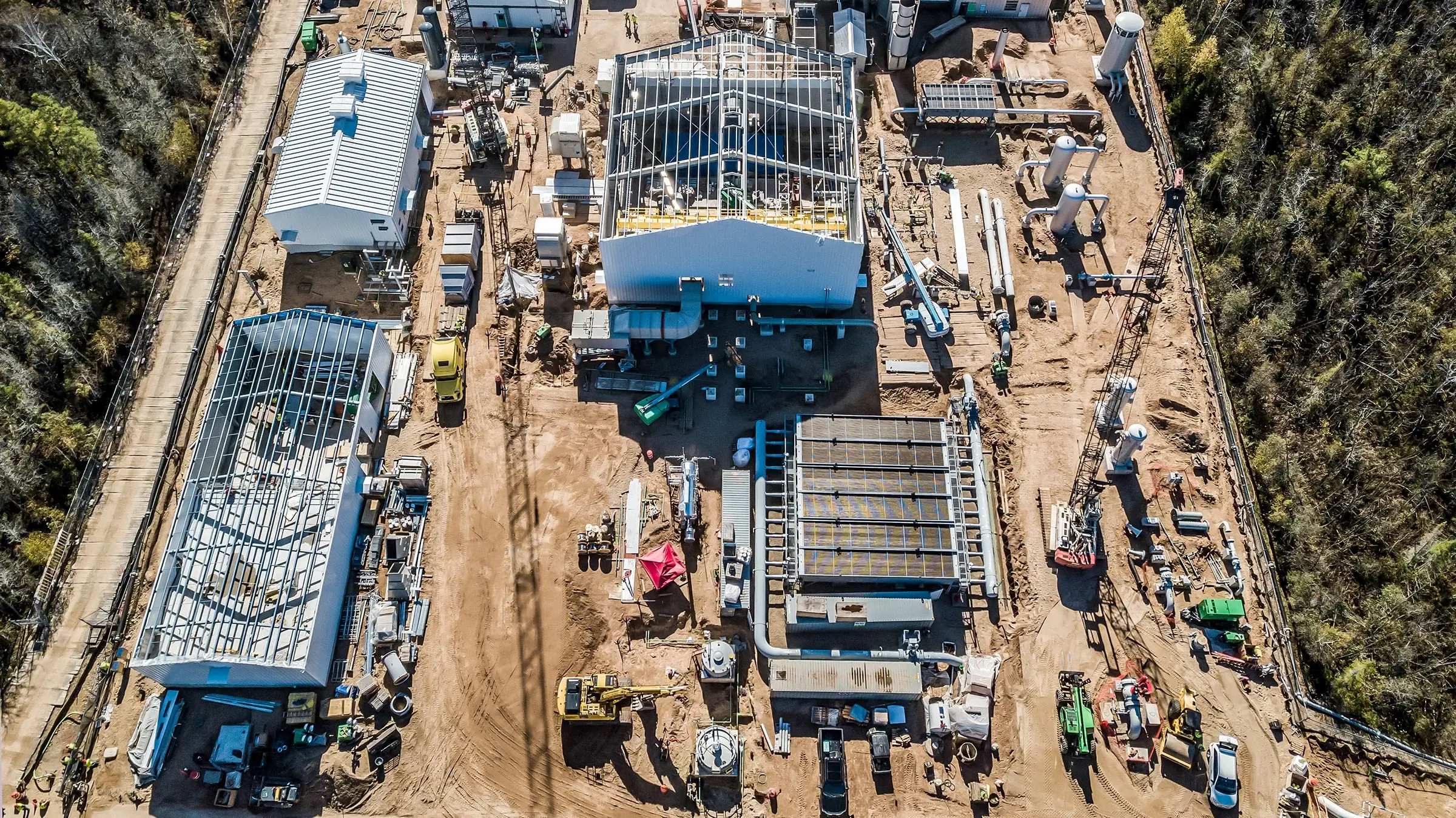 A busy jobsite consisting of buildings and pipes.