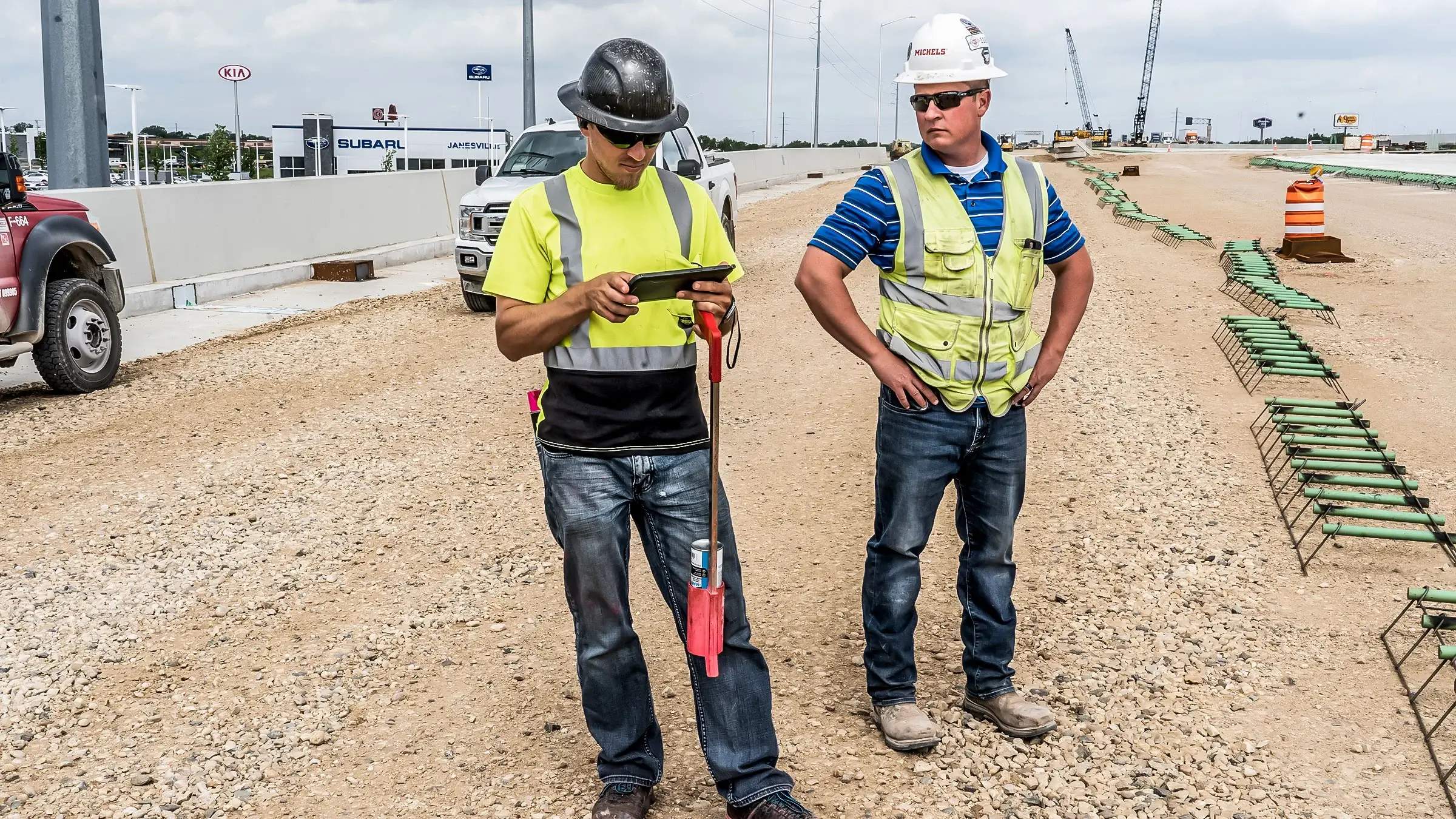 Two Michels Road & Stone crew members assist in operating a remote control device.