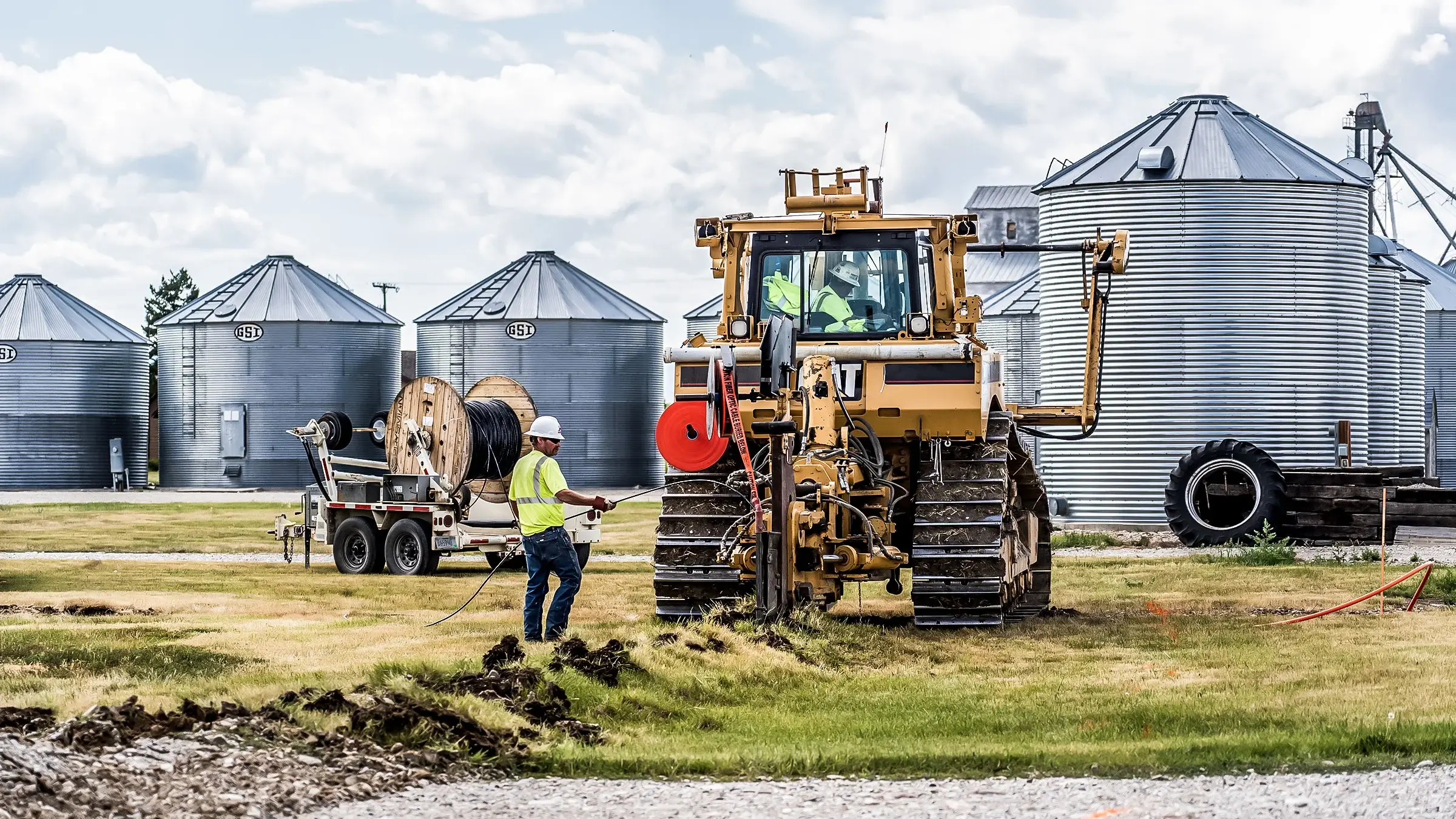 A large dozer and plow attachment buries fiber cable for a communications network