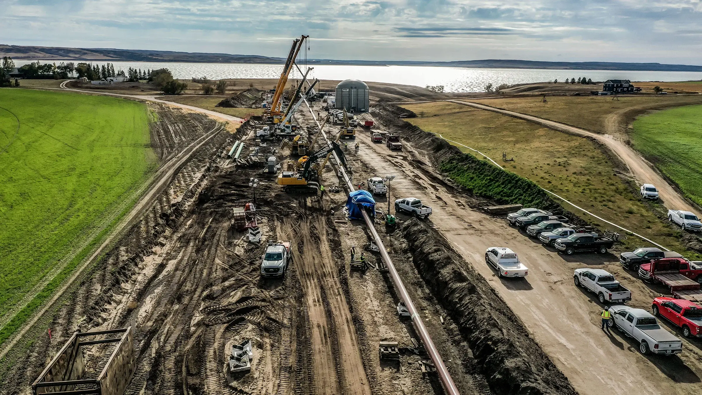 A large pipe is installed under a river through the HDD method of construction.