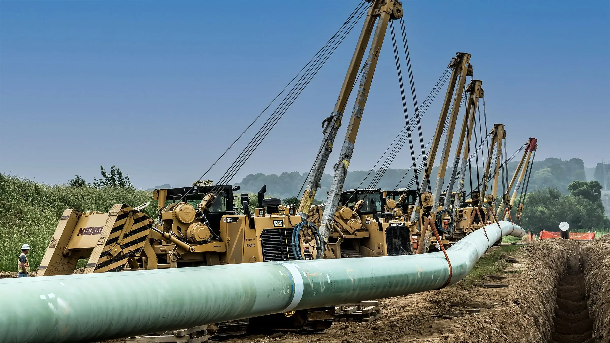 A Michels Pipeline crew prepares to lower a section of pipe into a trench
