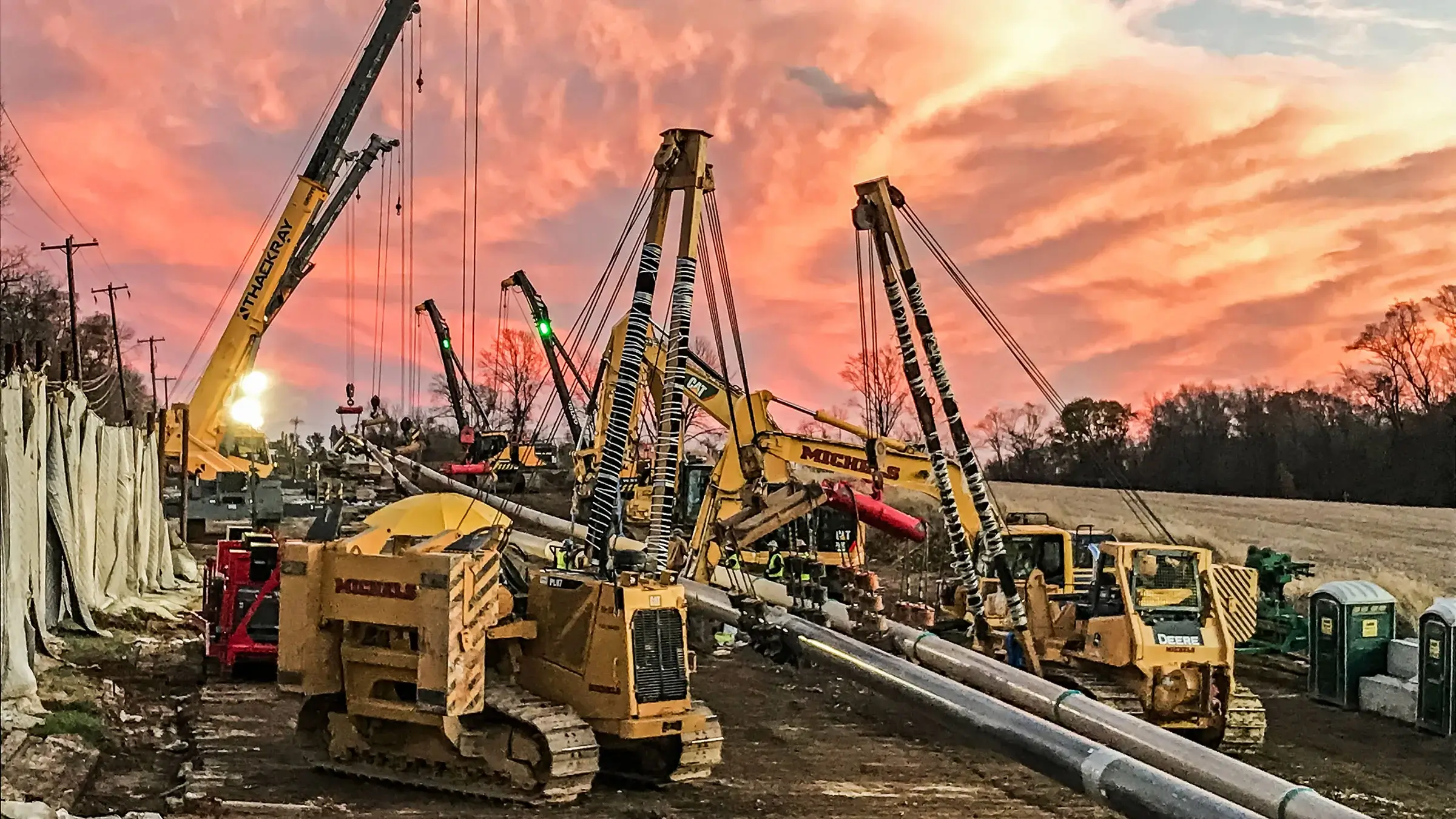 A crew uses HDD to install a pipe during a brilliant sunset