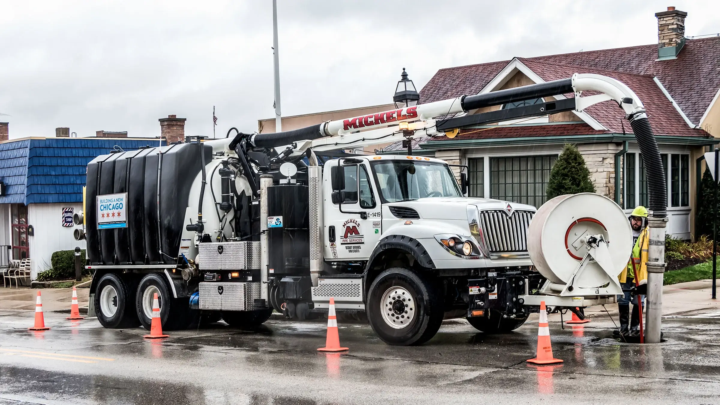 A crew lowers a camera into a sewer manhole