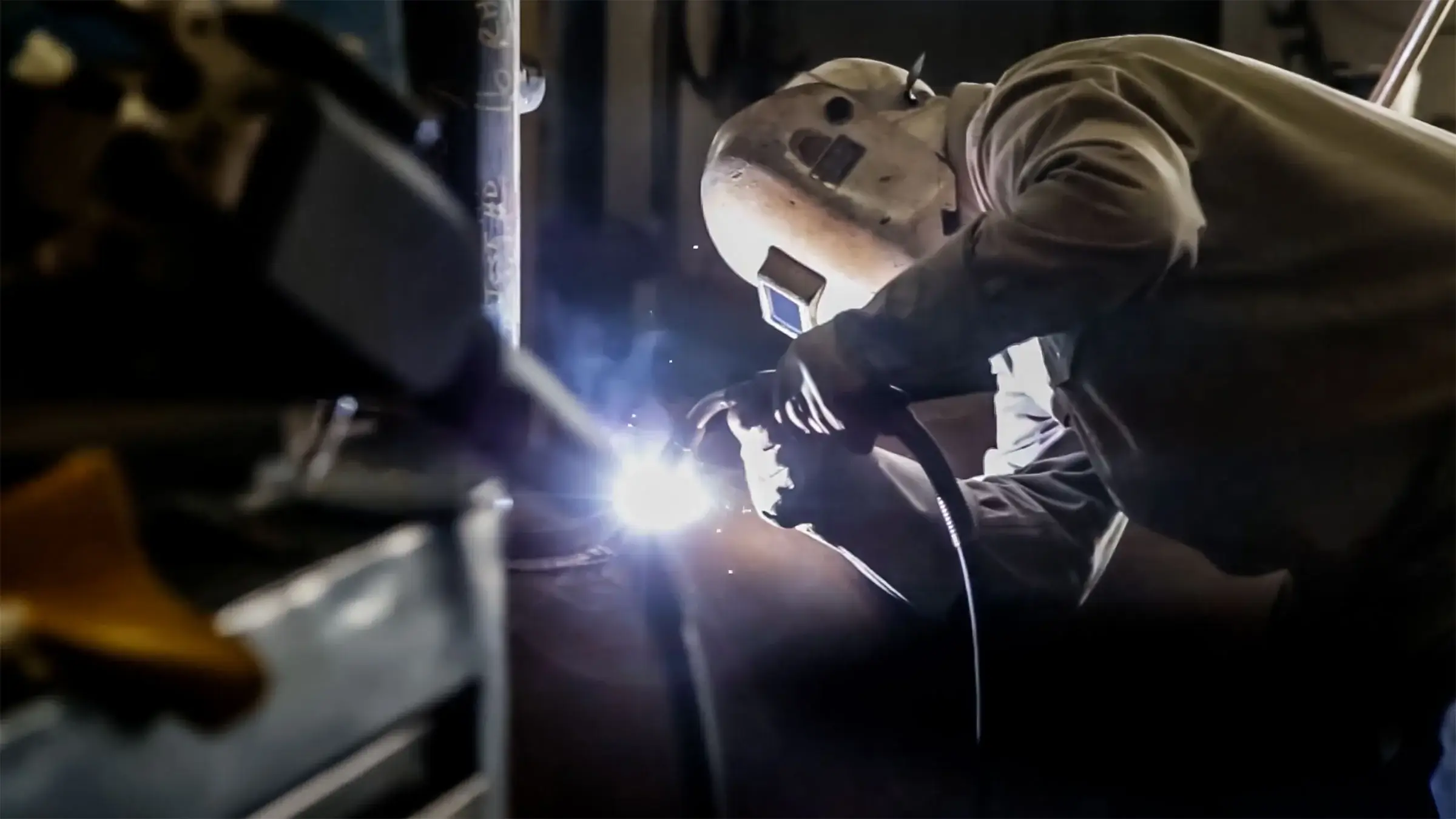 A welder works on a small fabrication job.