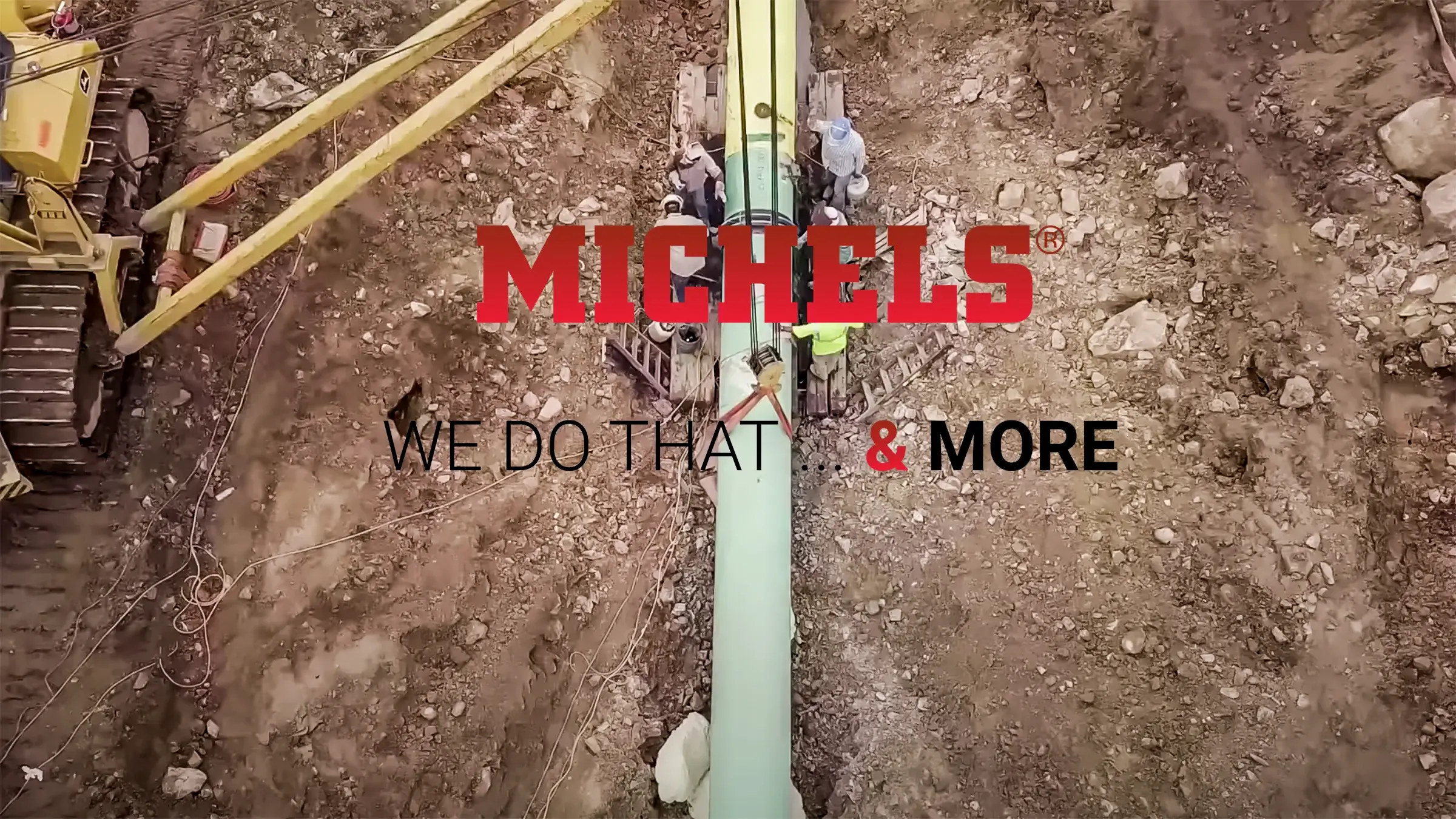 Aerial view of pipeline with Michels logo and slogan overlay
