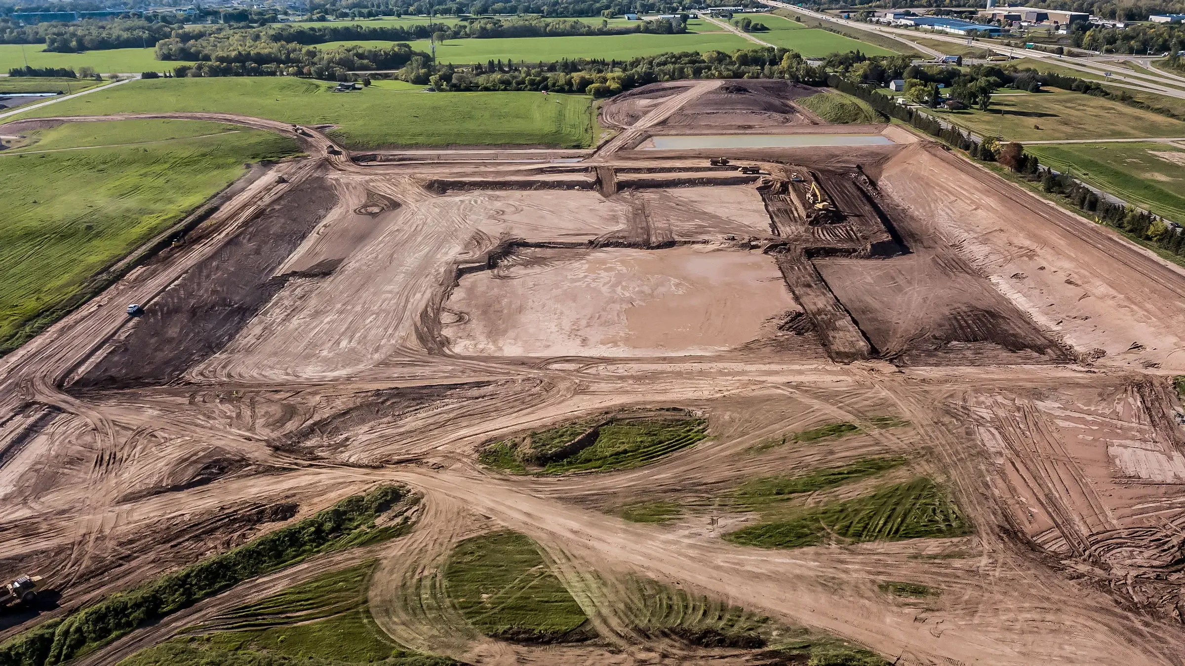 An aerial view of a large mass excavation site at a landfill