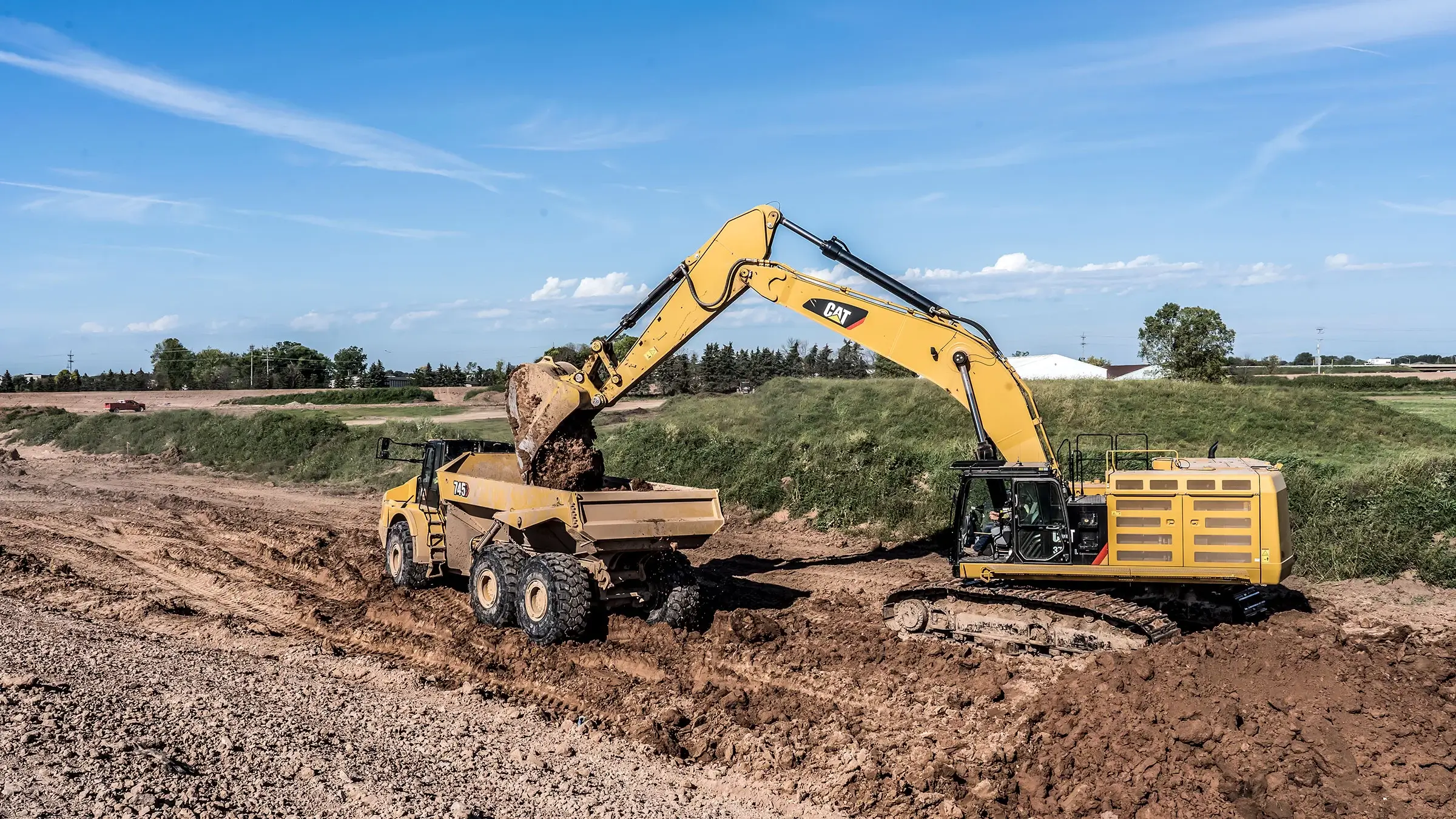 An excavator loads a dump truck with aggregate.