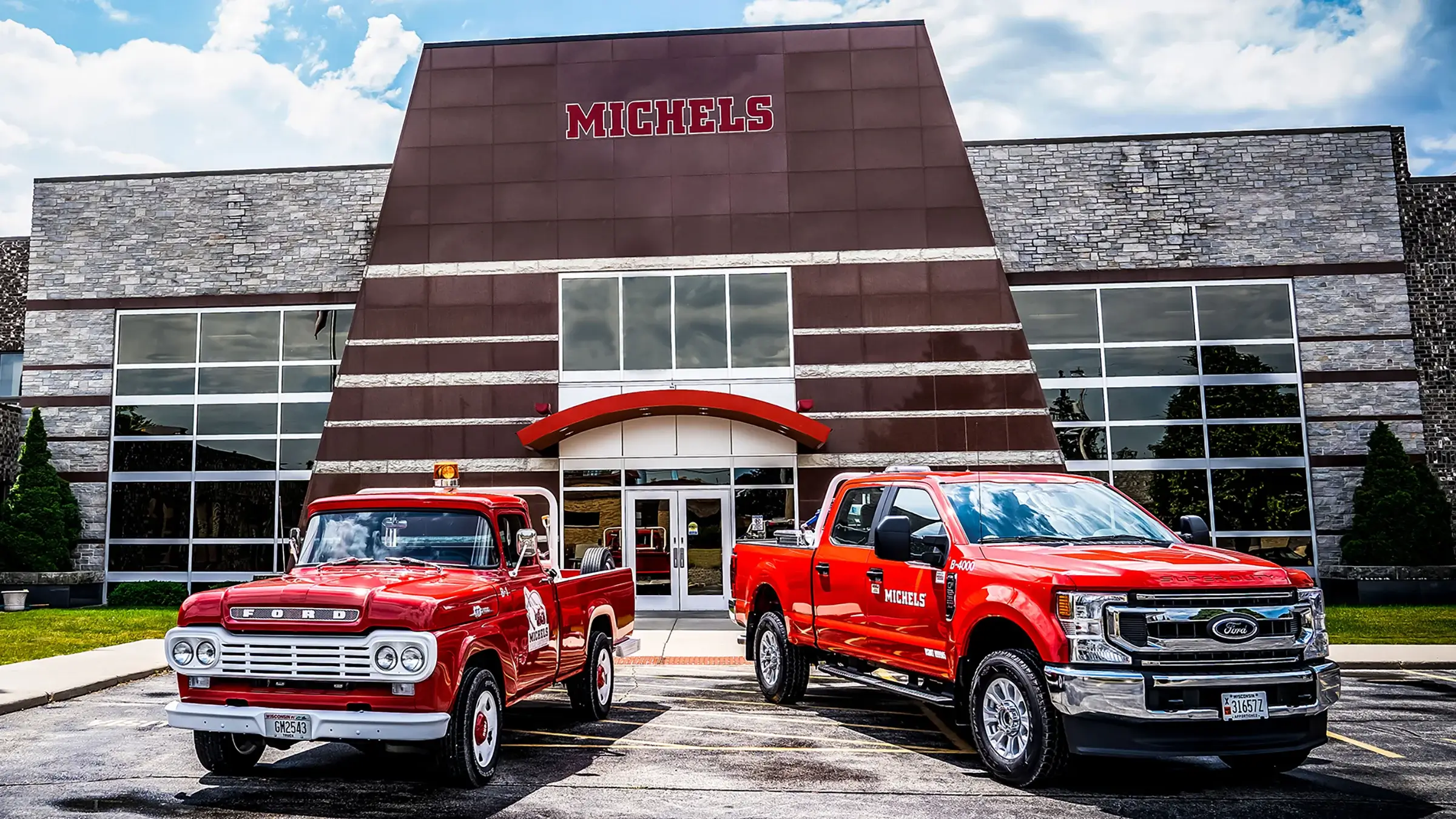 A vintage and new Michels pickup truck sit in front of the main Brownsville Headquarters.
