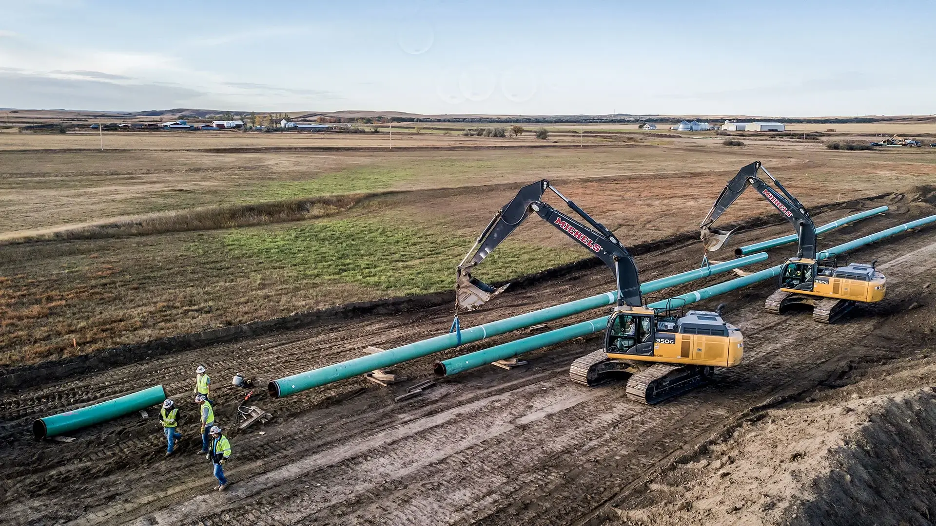 Excavators transport pipeline into place