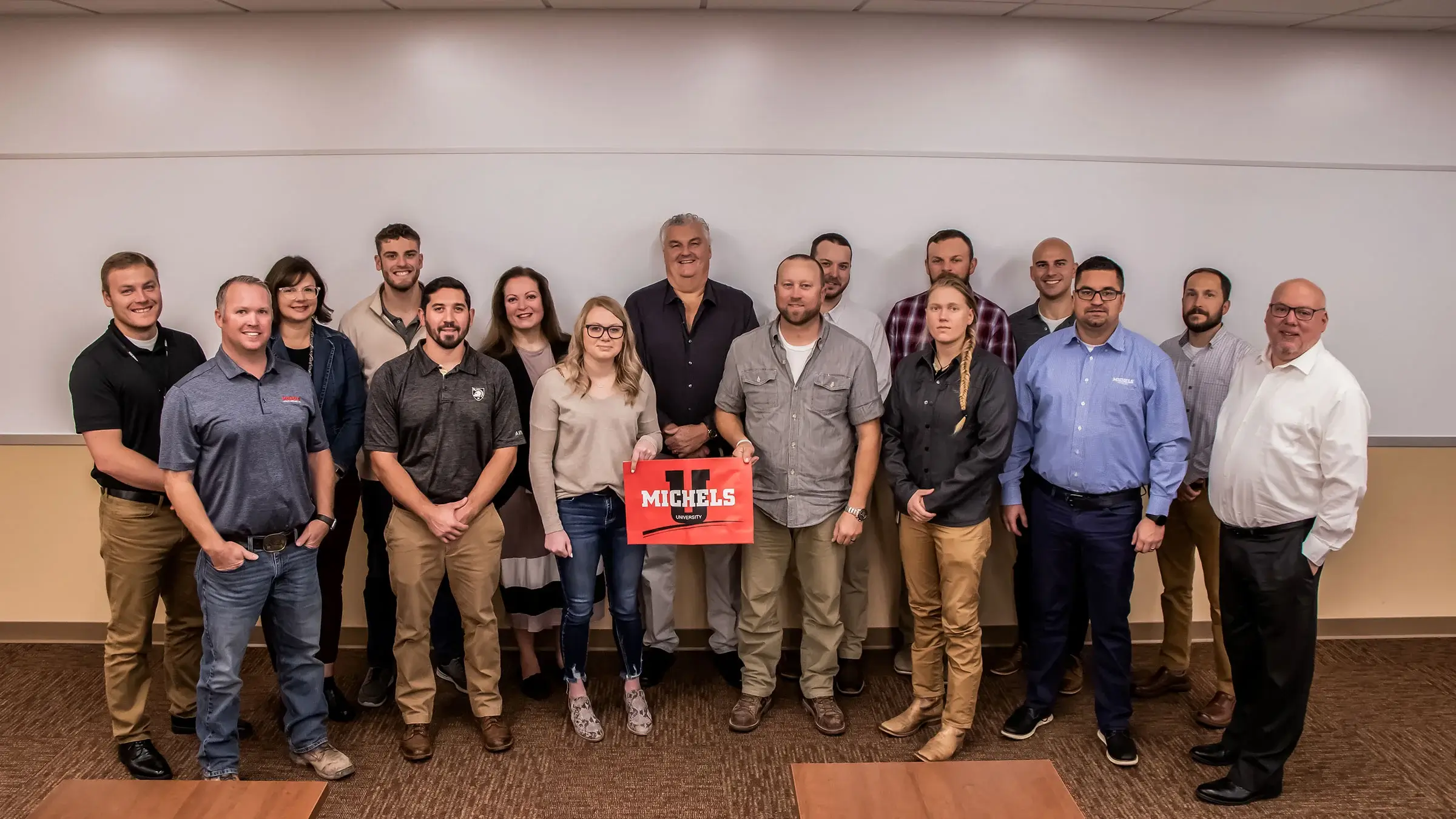 Pat Michels stands with project managers during a Michels University training
