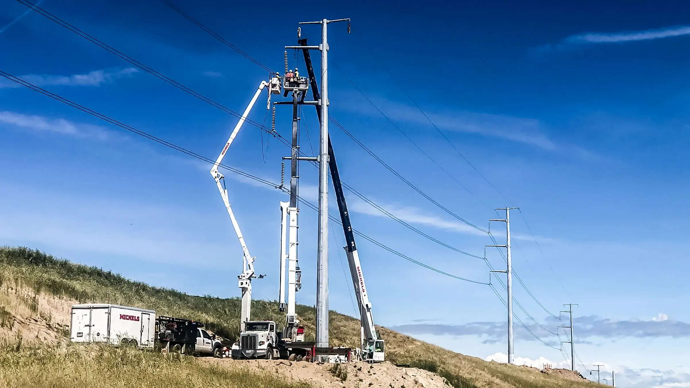 Michels Pacific Energy crew works out of bucket trucks on power lines