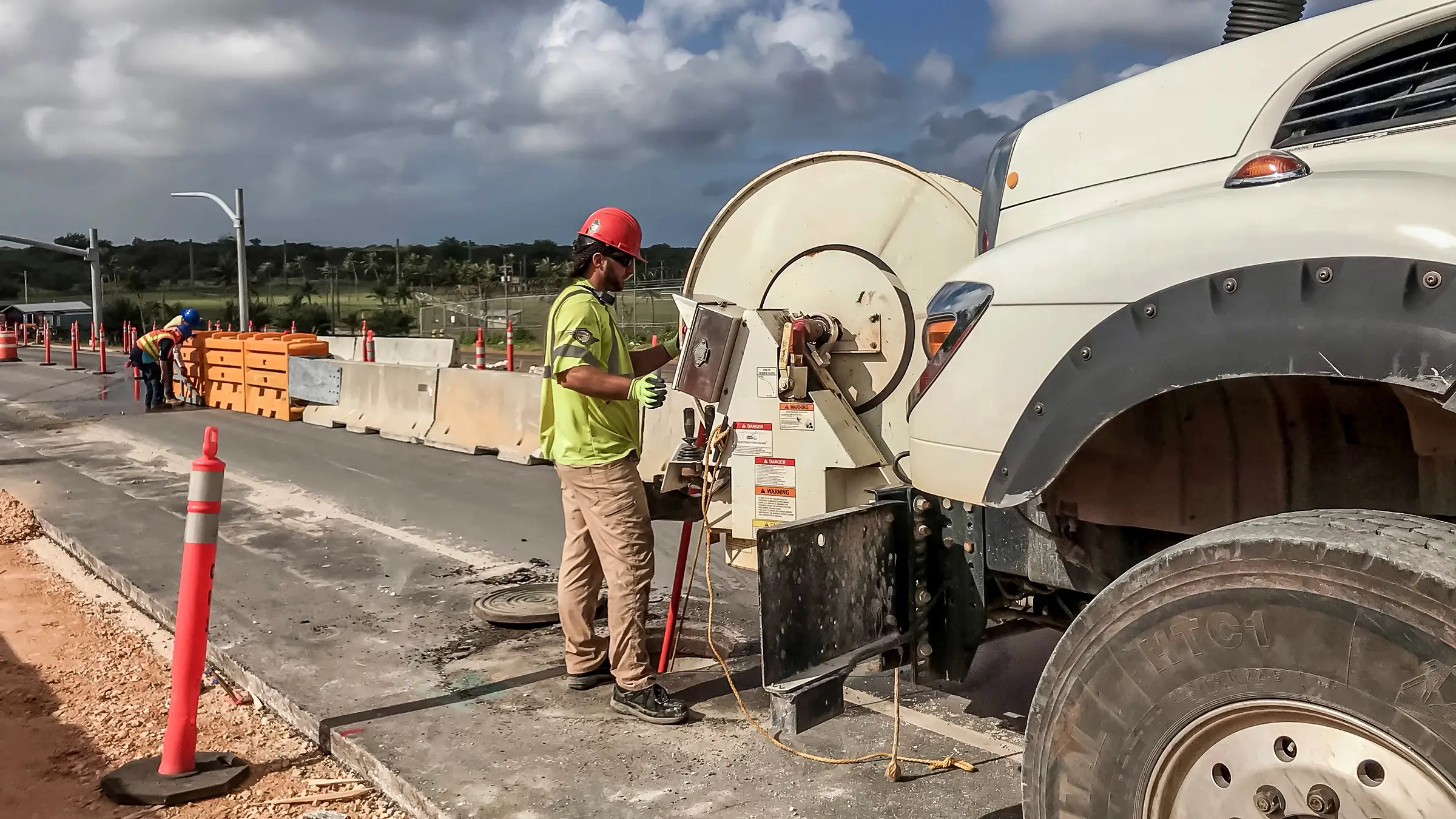 A crew member works on a roadside in Guam