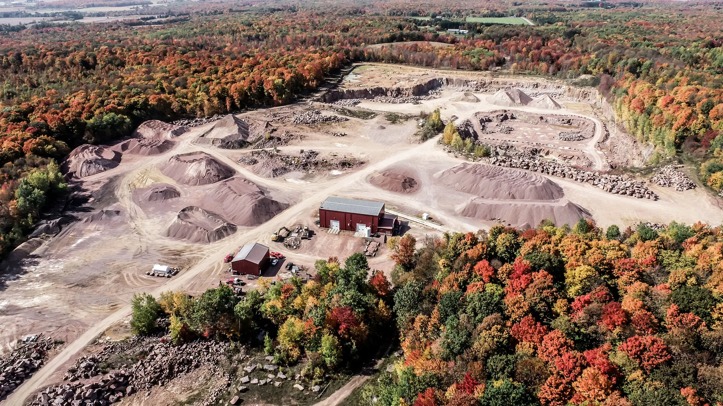 A large quarry surrounded by an autumn forest