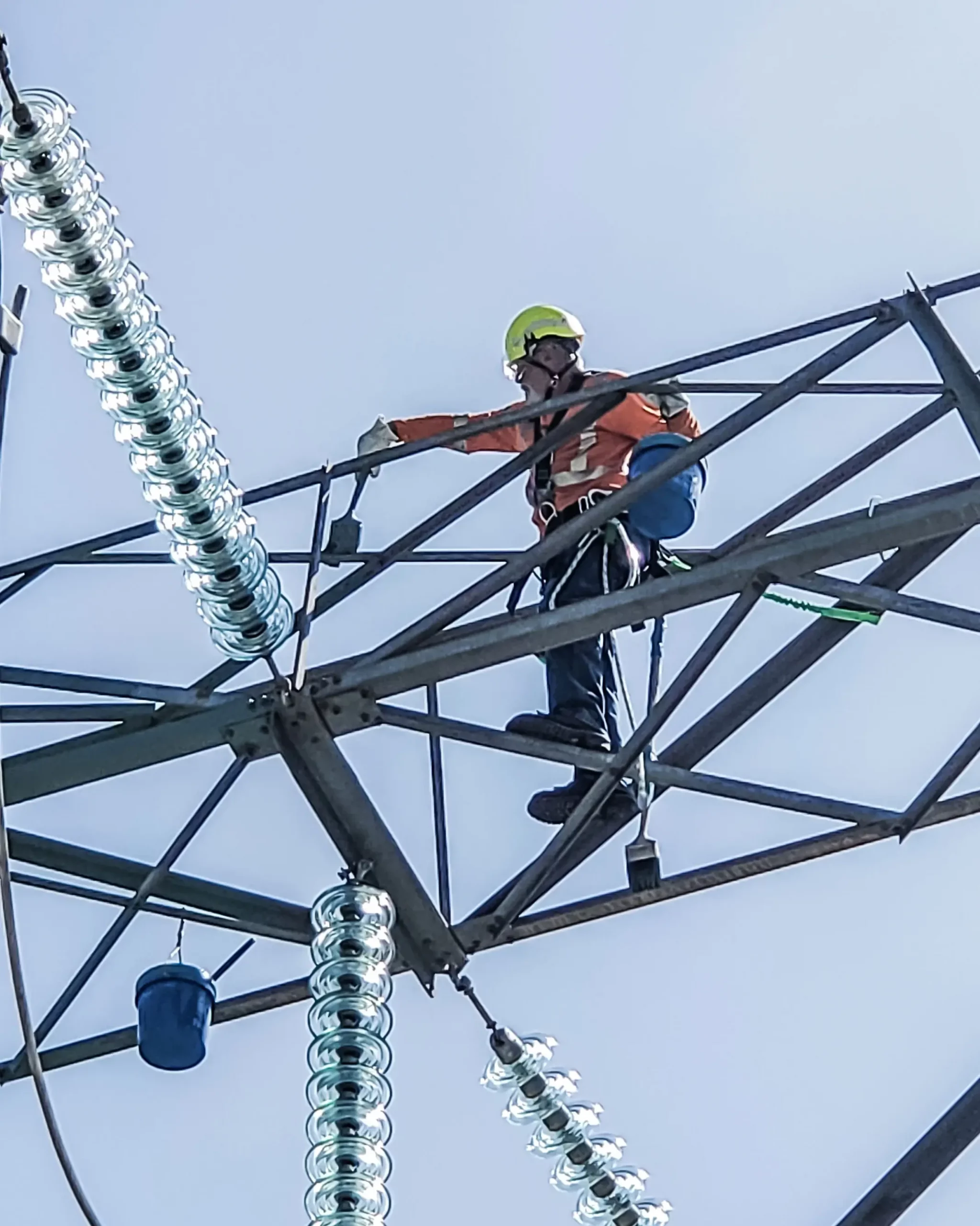 Crew member paints tower while wearing PPE.