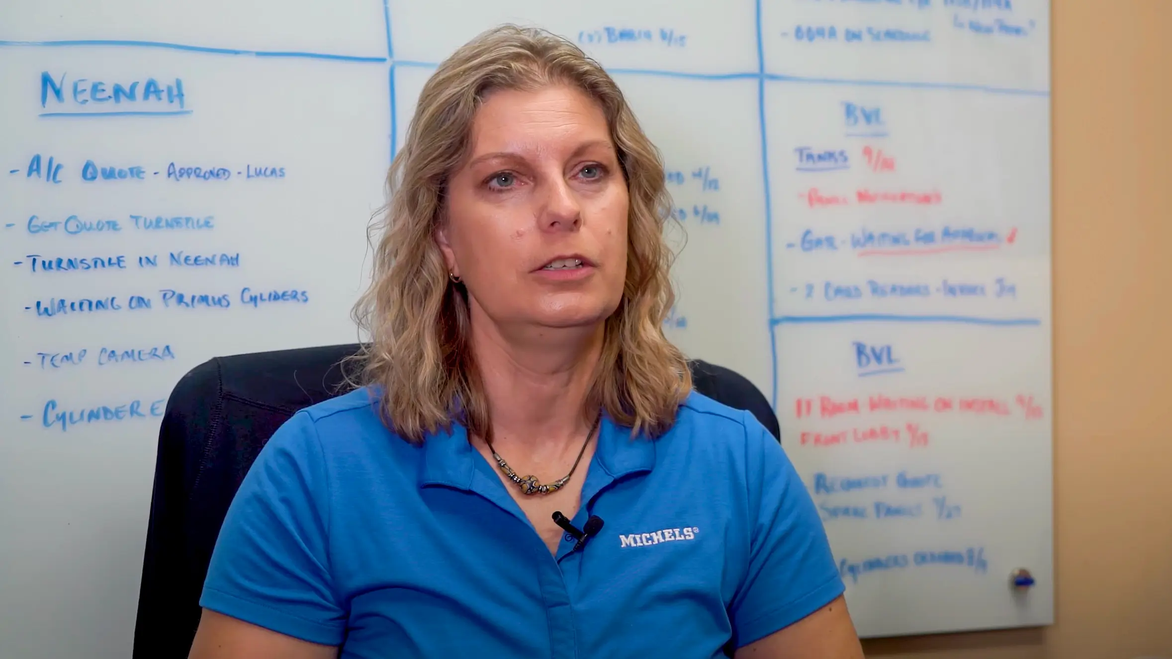 Woman talks in front of a whiteboard.