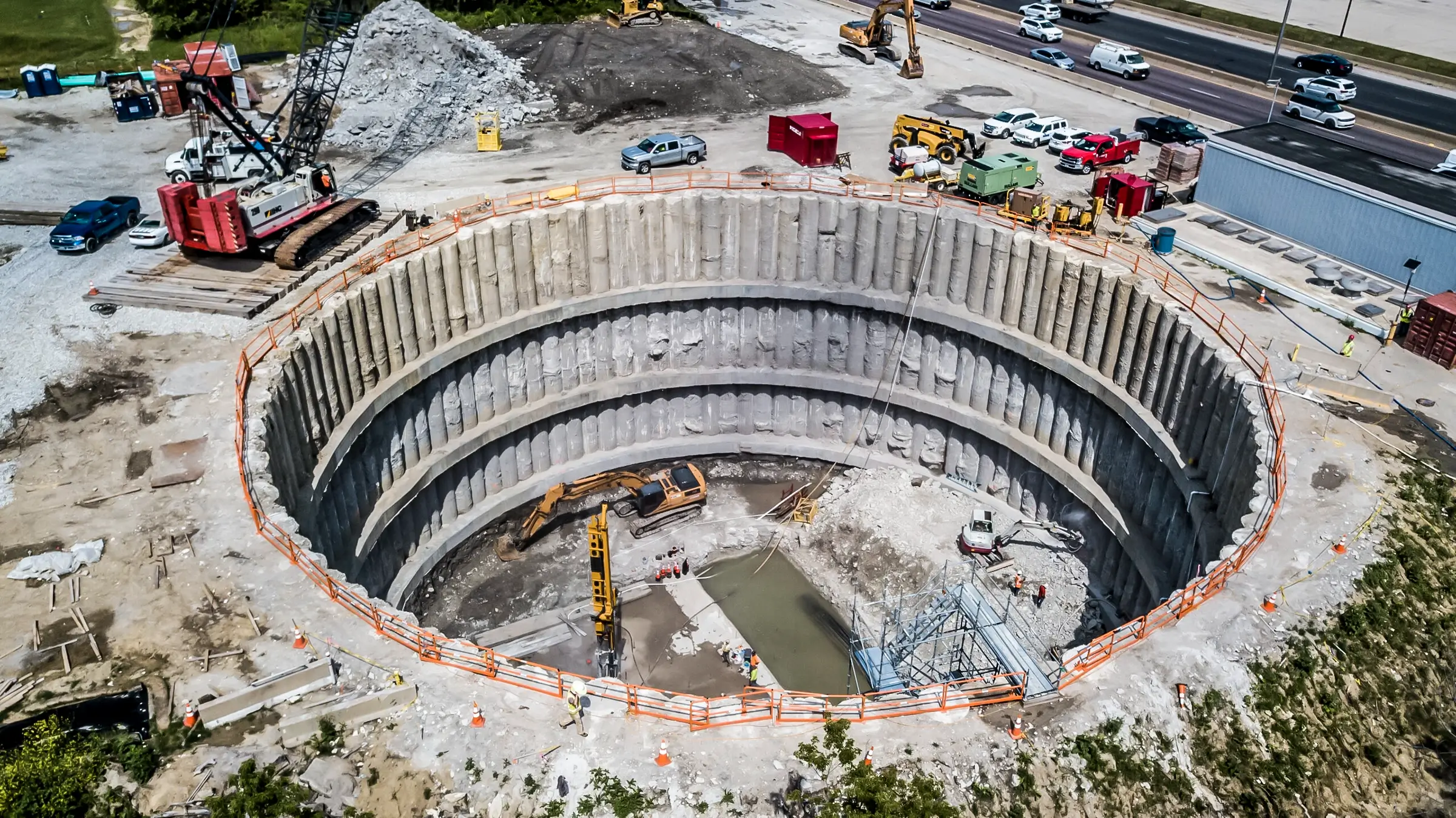 A waterproof secant pipe shaft supports an excavated construction site