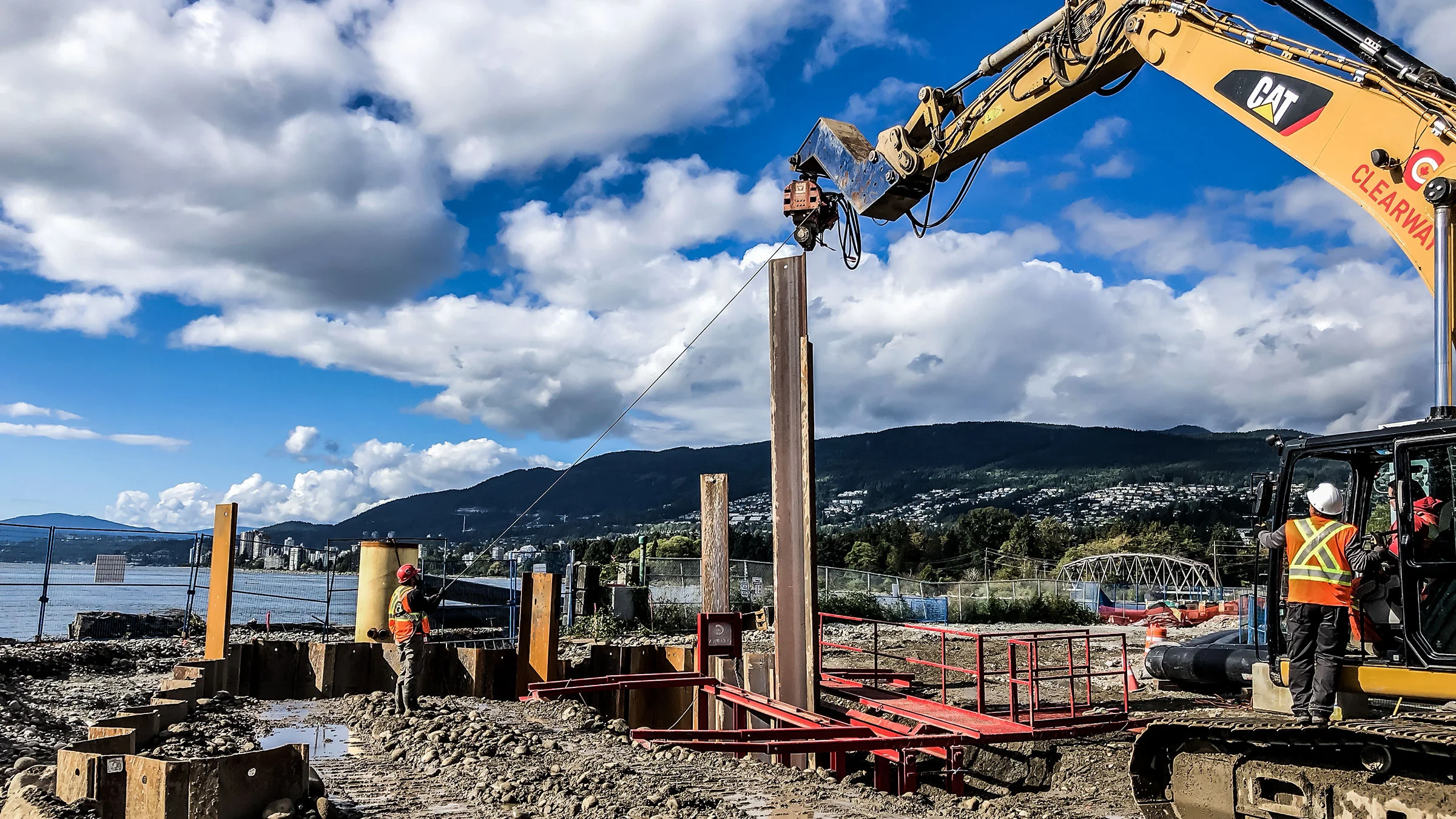 A Michels crew works on a foundations job near a river and mountains in Canada.