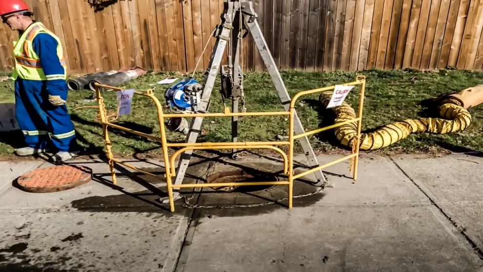 A crew member works near a manhole.