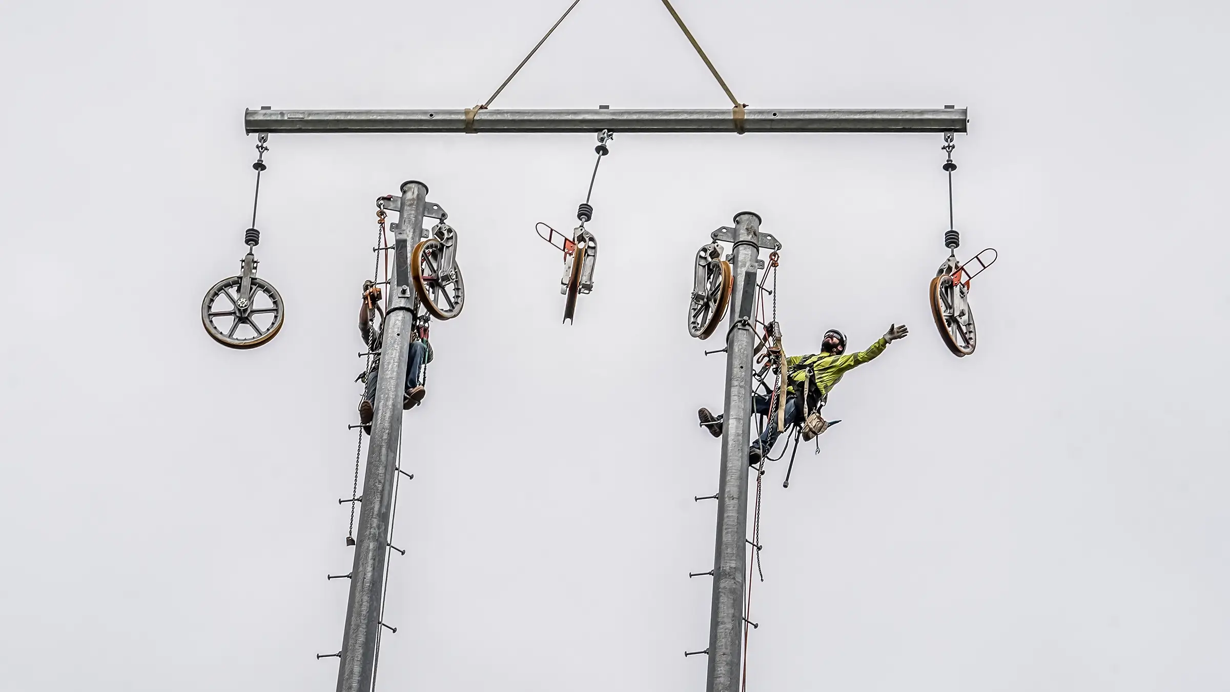 Linemen work atop of large power poles to place units in place.