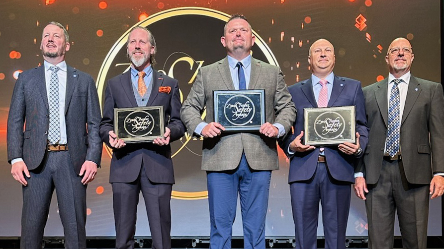 Five men stand on a stage with ZISA construction awards.