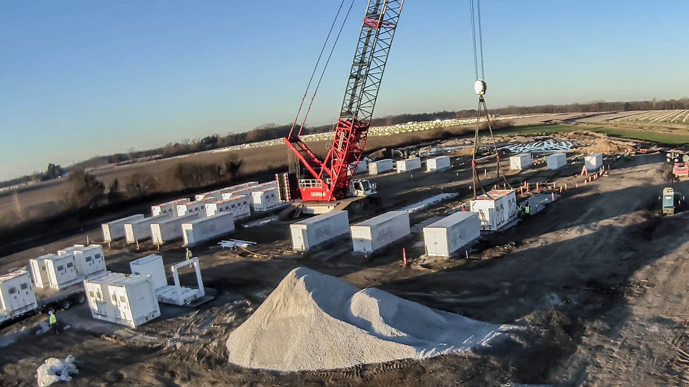 Large red crane on a BESS jobsite.