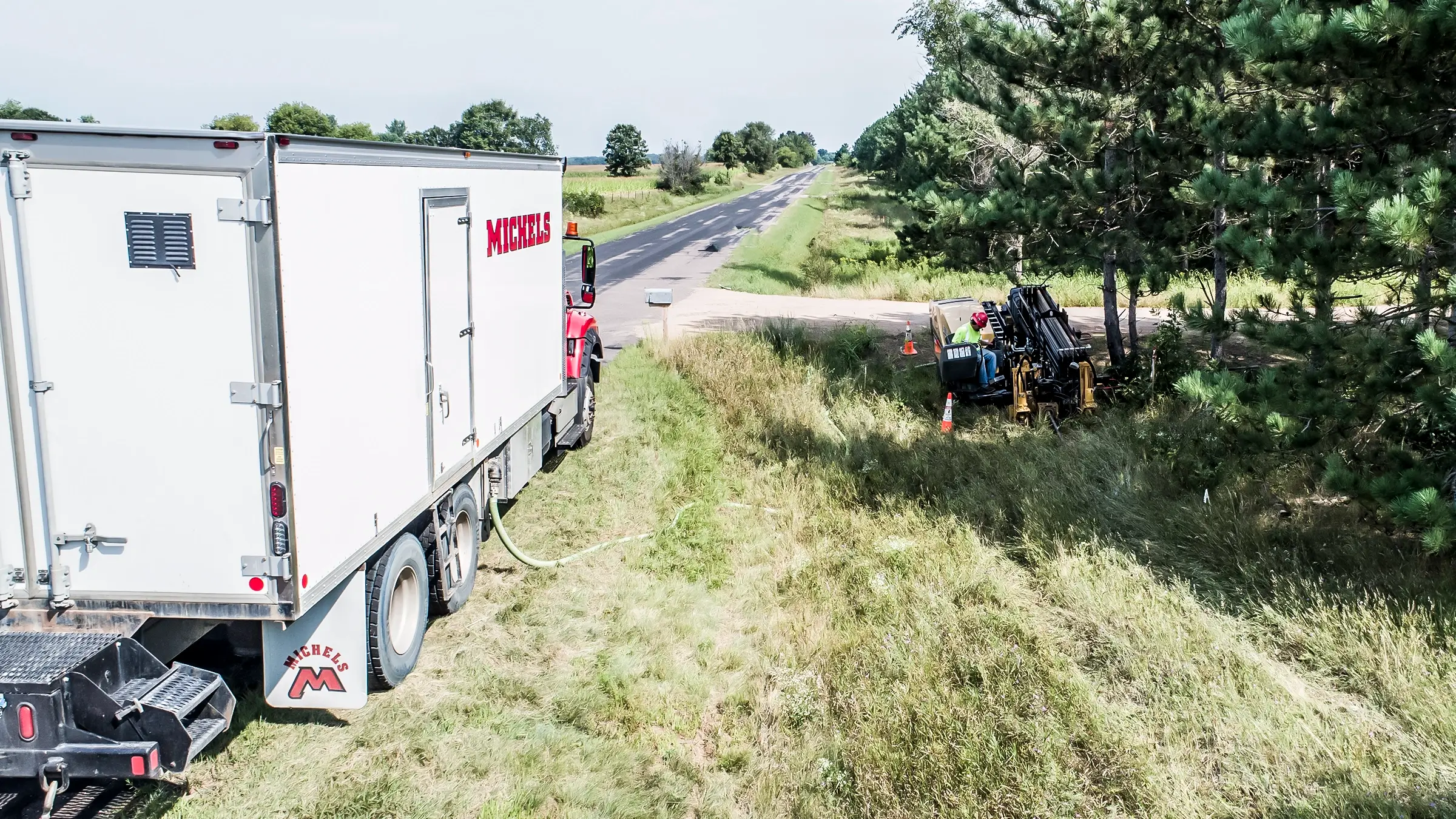 An HDD rig installs underground cable near a rural roadside.